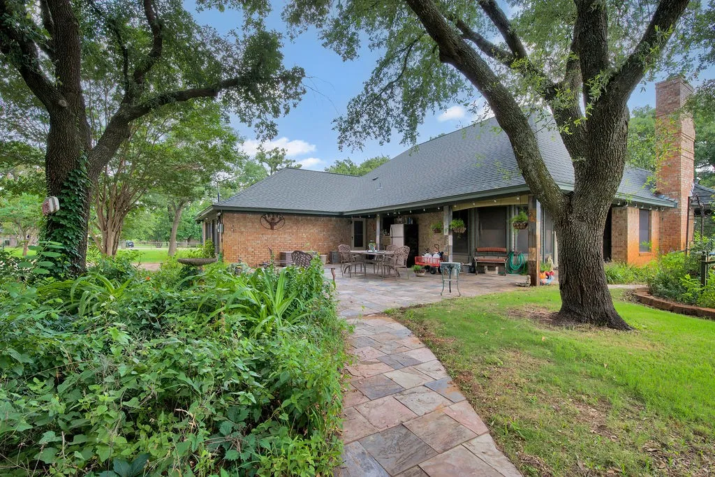 Brick exterior residence with a dark shingle roof and a prominent brick chimney