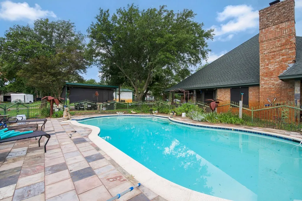 Freeform swimming pool featuring a perimeter tile band and a wide coping edge