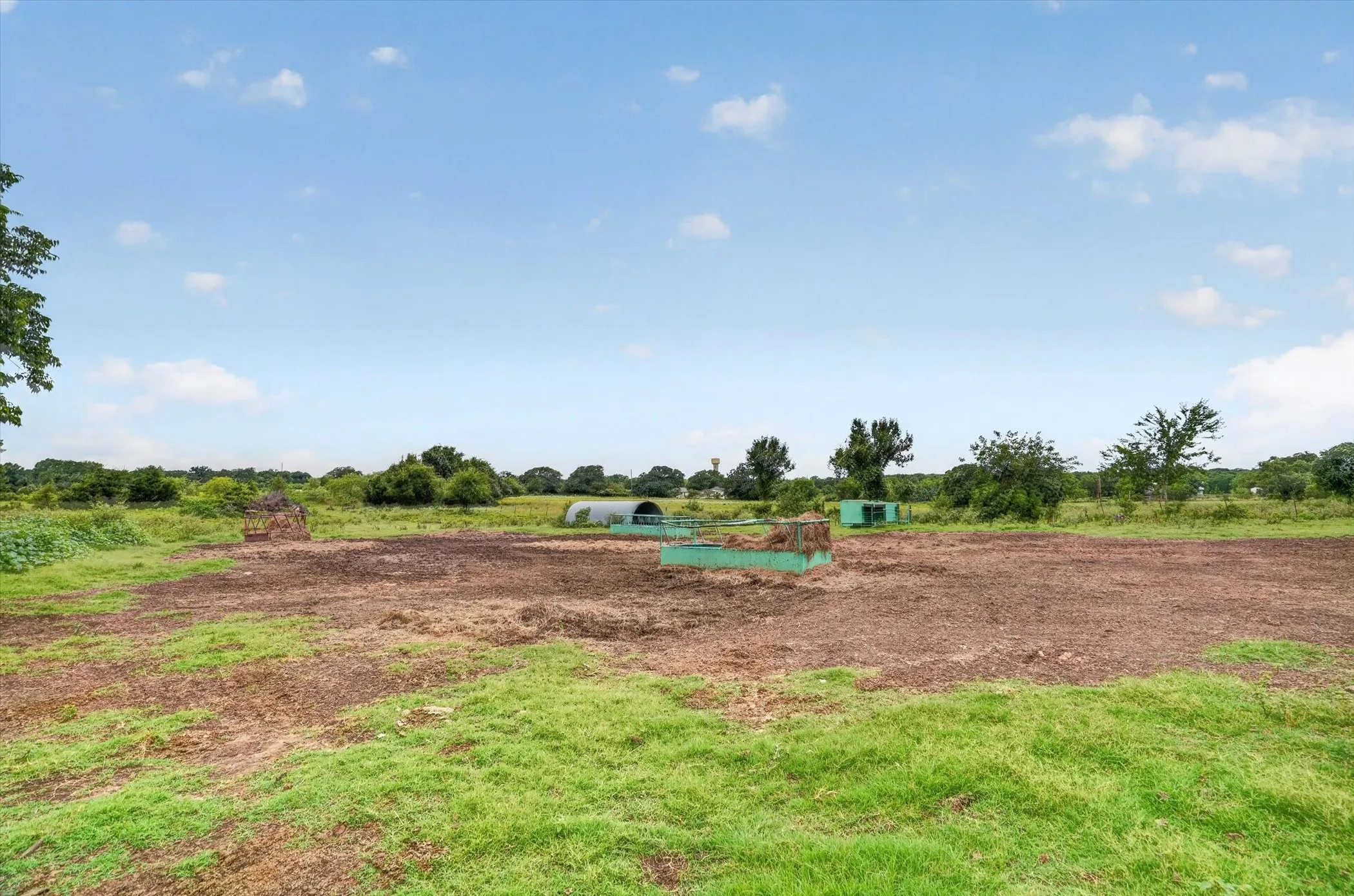 Expansive green space featuring partial grassy areas and cultivated land