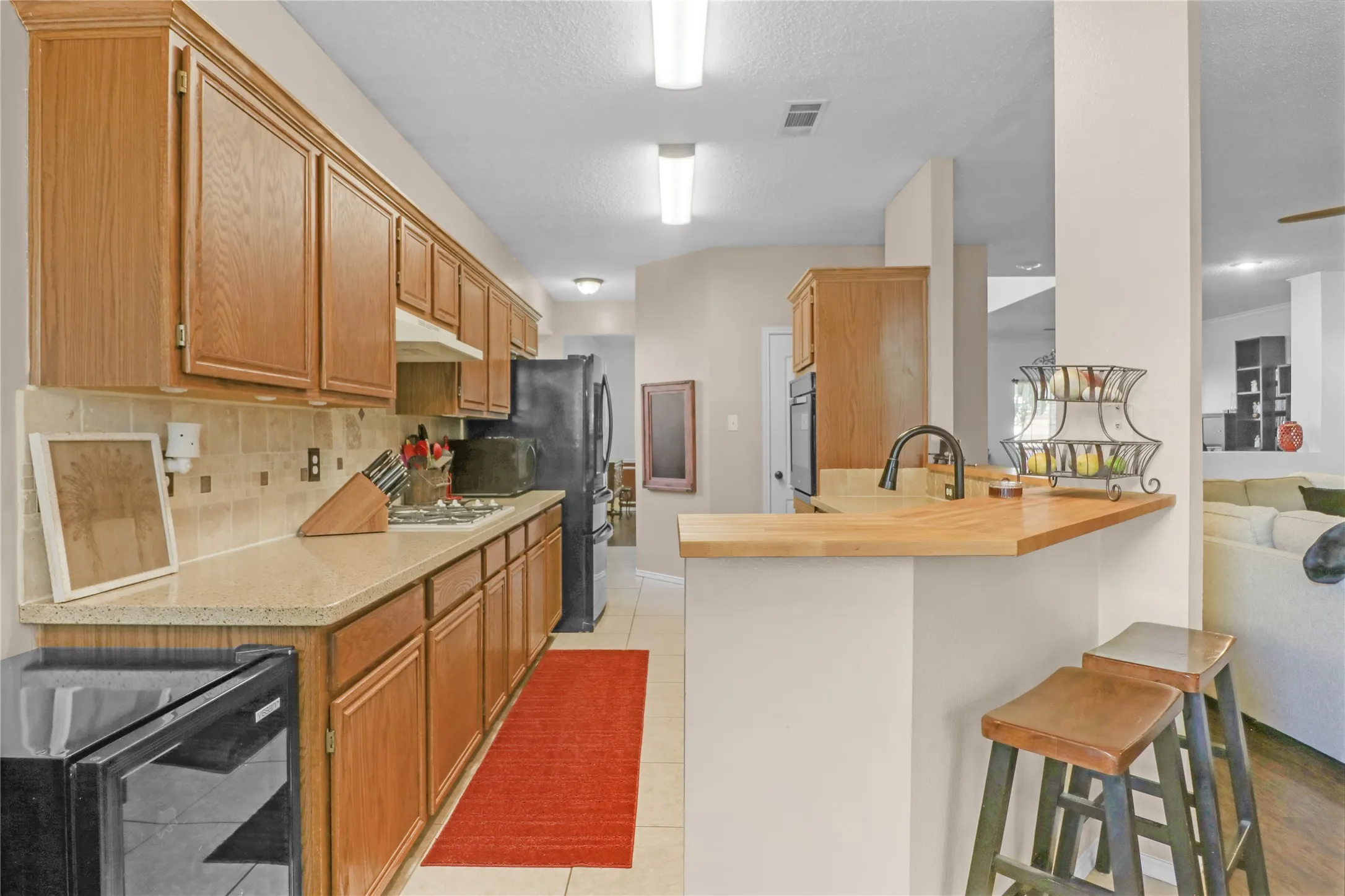 Kitchen with breakfast bar and tile backsplash.