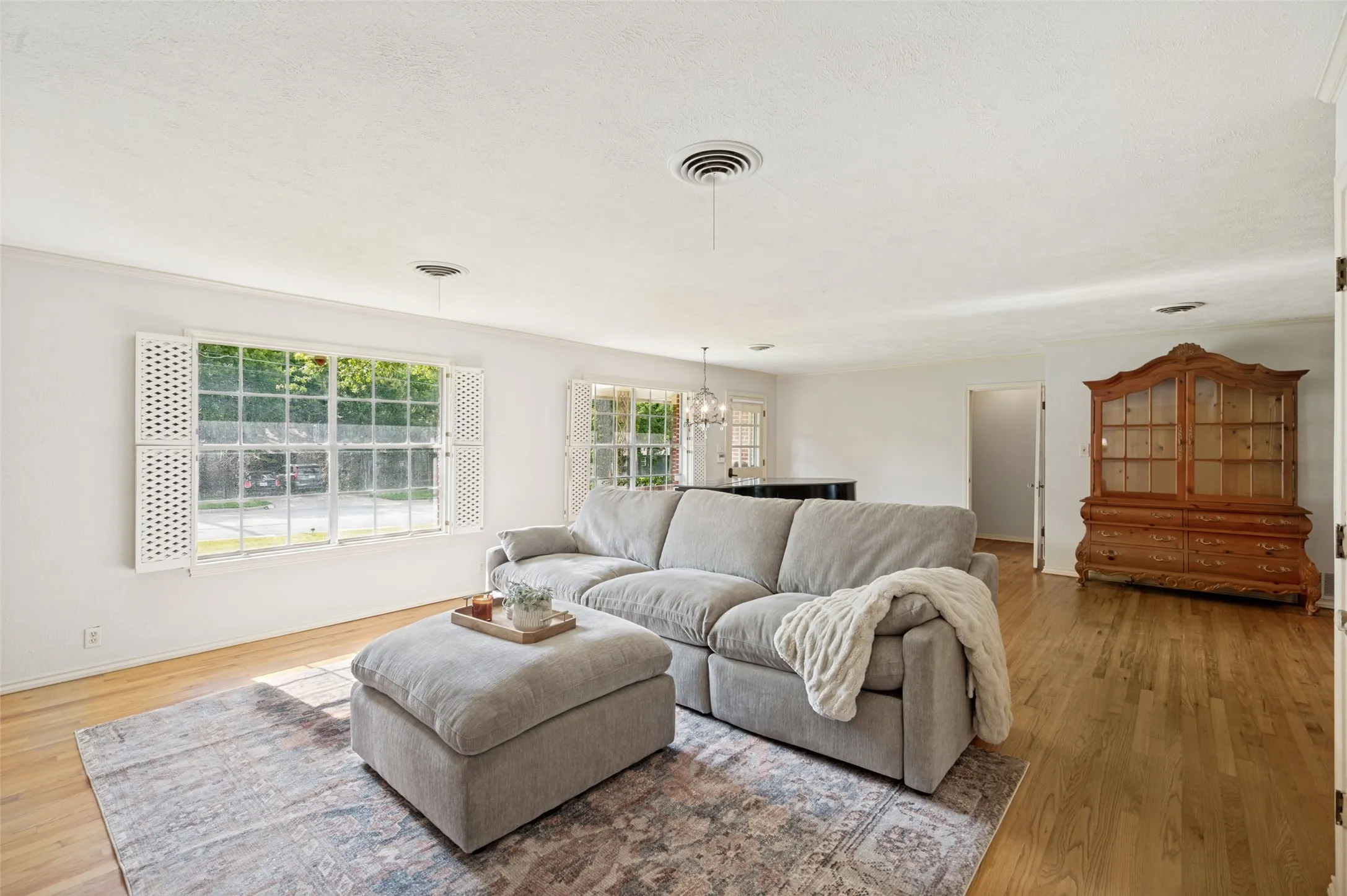 Large windows, abundant natural light, and a soft neutral color palette create a bright and inviting space.
