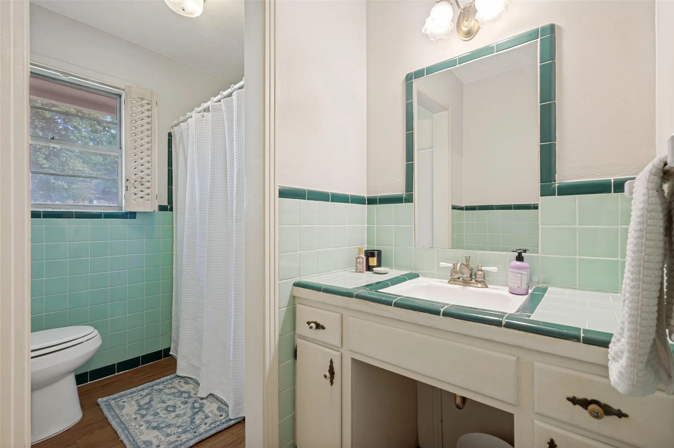 The large second bathroom is off the main hallway and features a separate vanity area.  Notice the vintage tile that looks as if were newly installed!