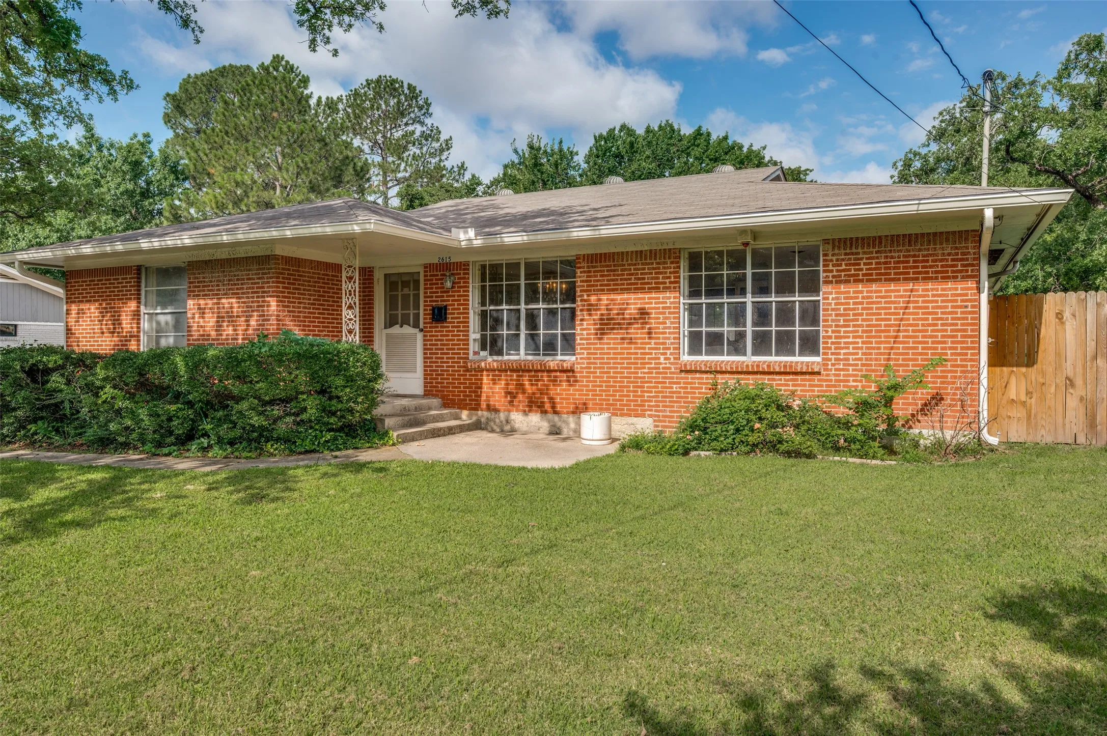 Classic ranch-style architecture featuring large picture windows and a welcoming covered entry.