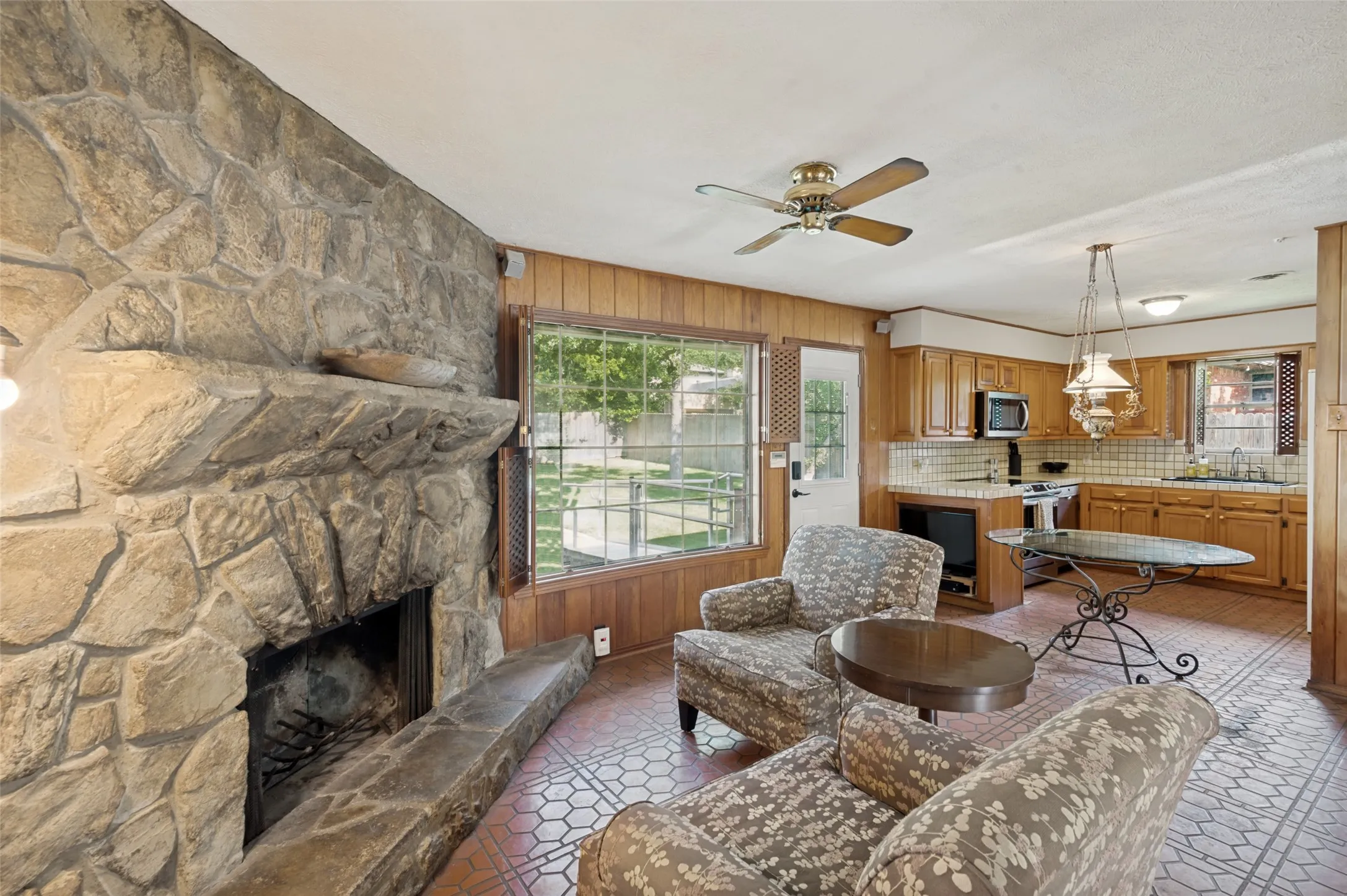 The floor-to-ceiling natural stone fireplace creates a strong focal point for this sitting area.
