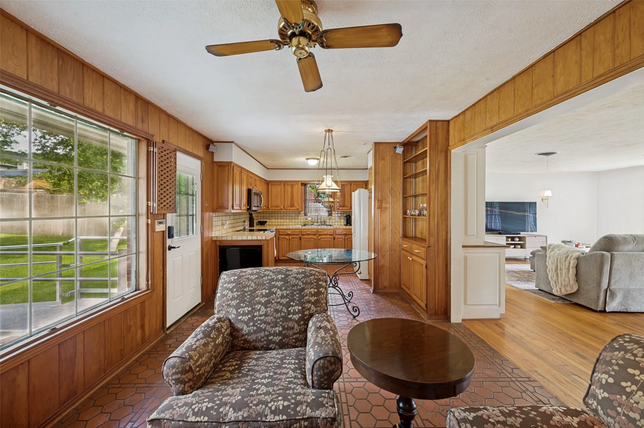 The large picture window and glass-paneled door bring in natural light and provide views of the backyard.