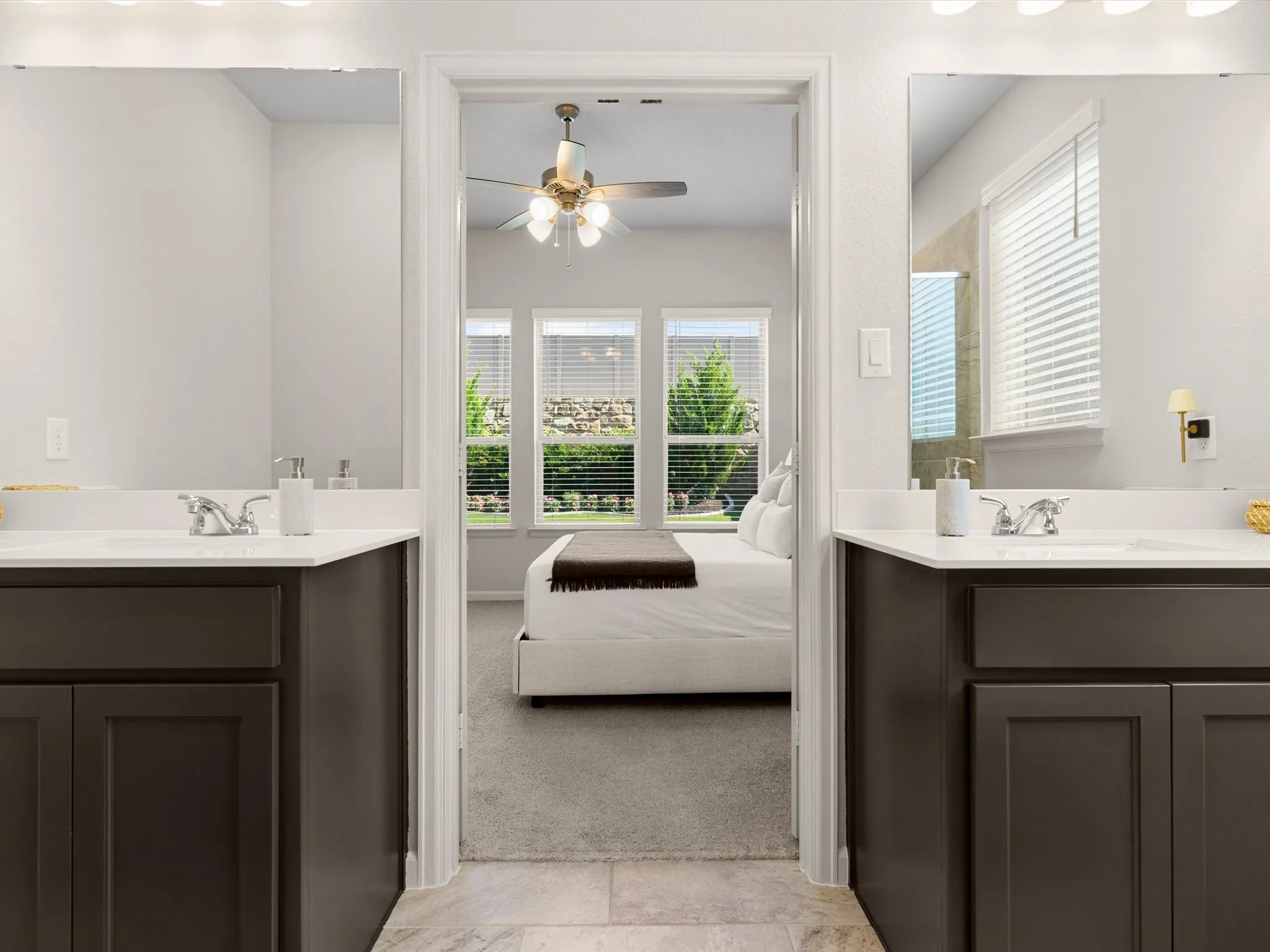 Primary bathroom featuring dual vanities, walk-in shower, and ample storage.