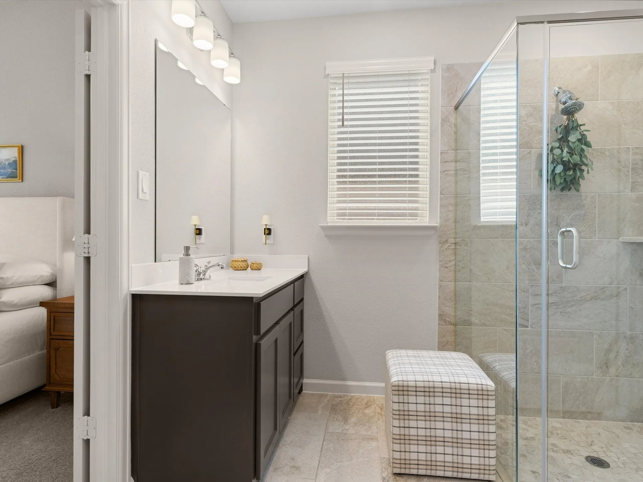Primary bathroom featuring dual vanities, walk-in shower, and ample storage.