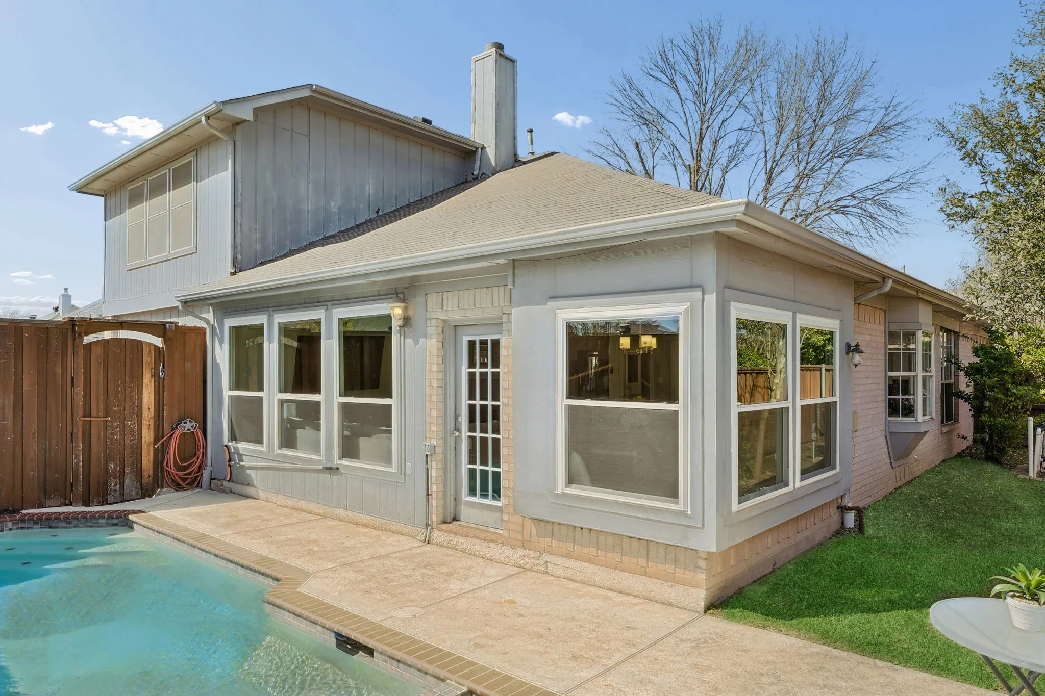 Private backyard featuring a swimming pool, concrete patio, and a privacy fence
