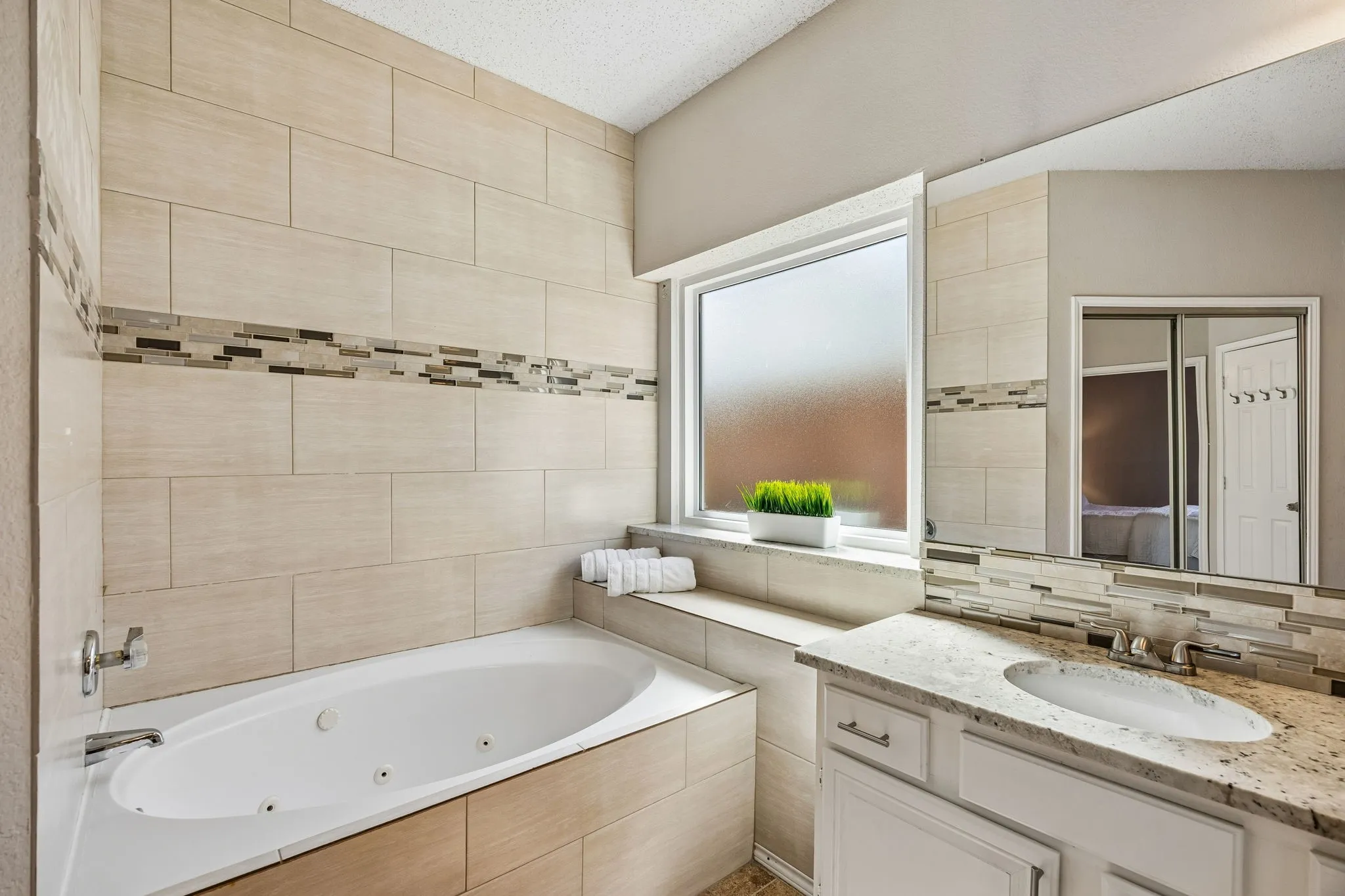 Integrated jetted tub with tile surround and frosted window