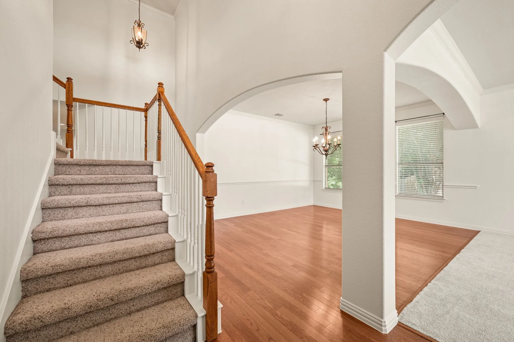 Carpeted staircase featuring wood handrails and white balusters