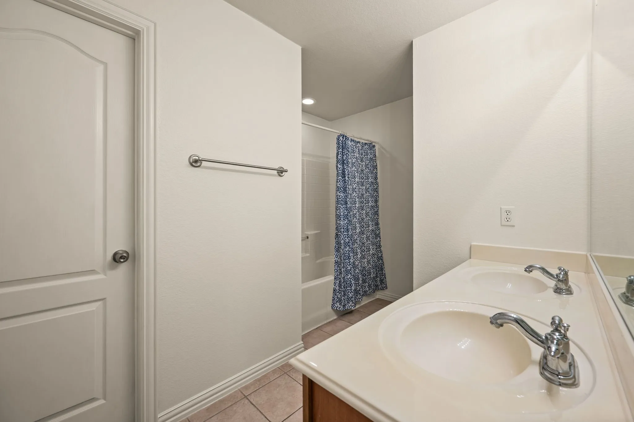 Bathroom featuring a double vanity with integrated sinks, chrome fixtures, and a spacious countertop
