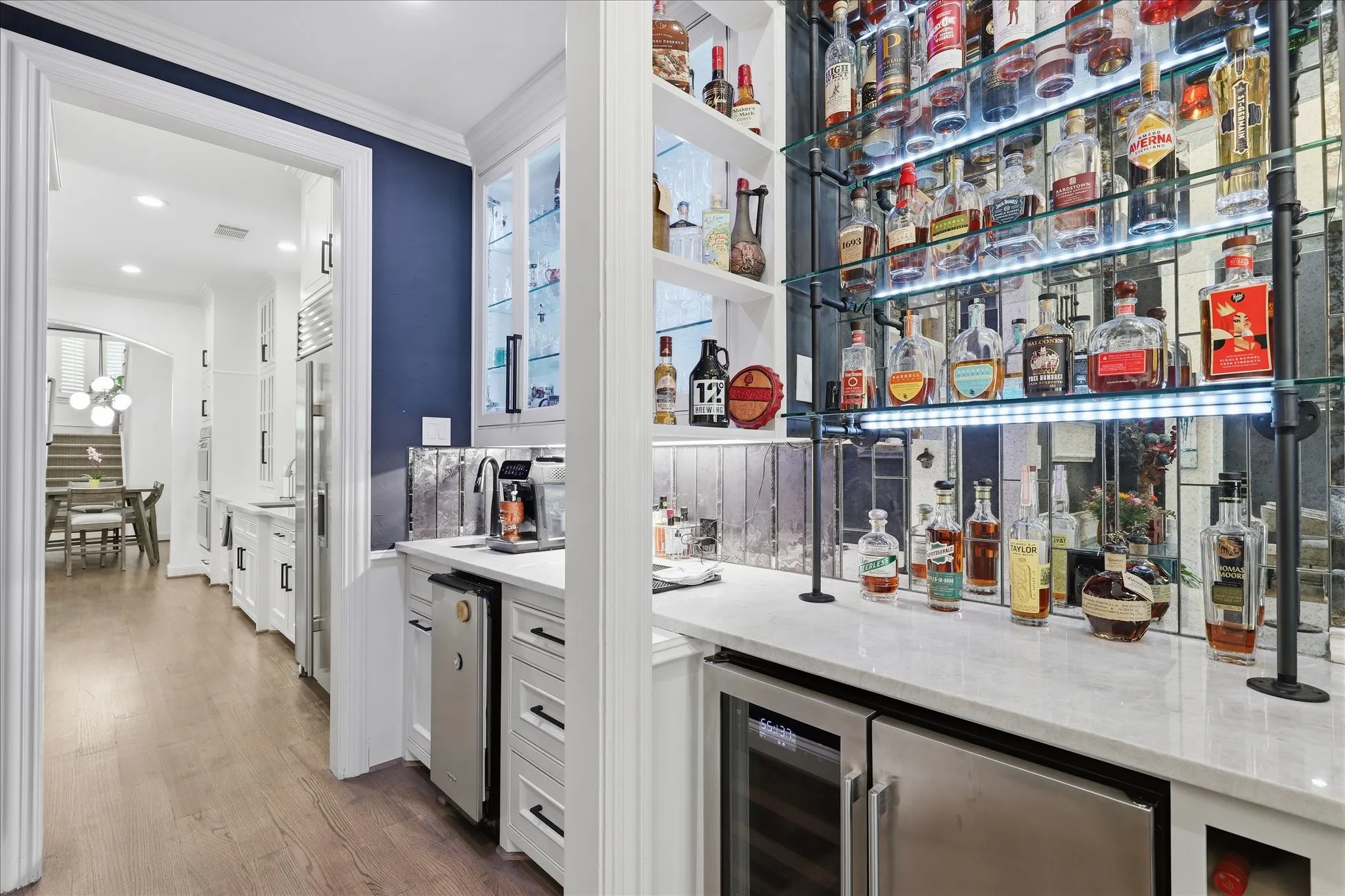 The stylish wet bar offers an ice maker, beverage refrigerator and plenty of shelving to display your collection of beverage choices.
