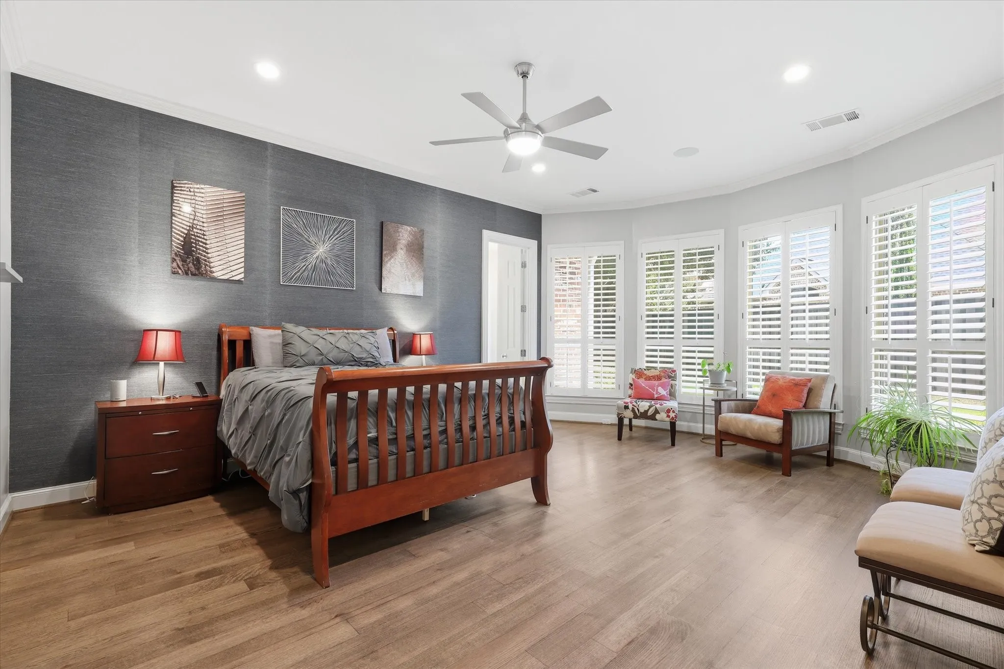 The Primary Bedroom is nicely sized with a Sitting area, wood flooring and Plantation Shutters.