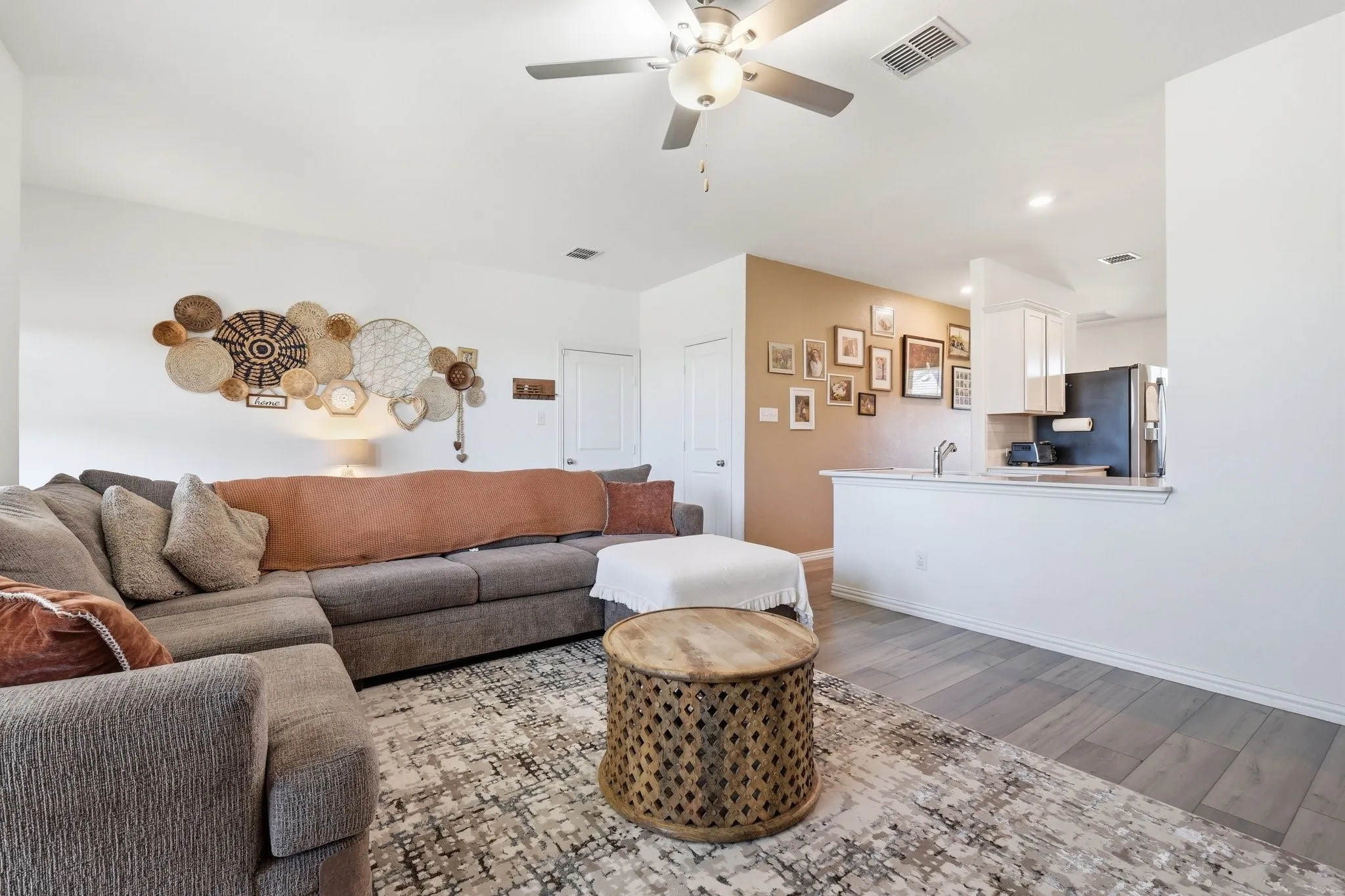 Open-concept living area with wood-finish flooring, recessed lighting, and a ceiling fan