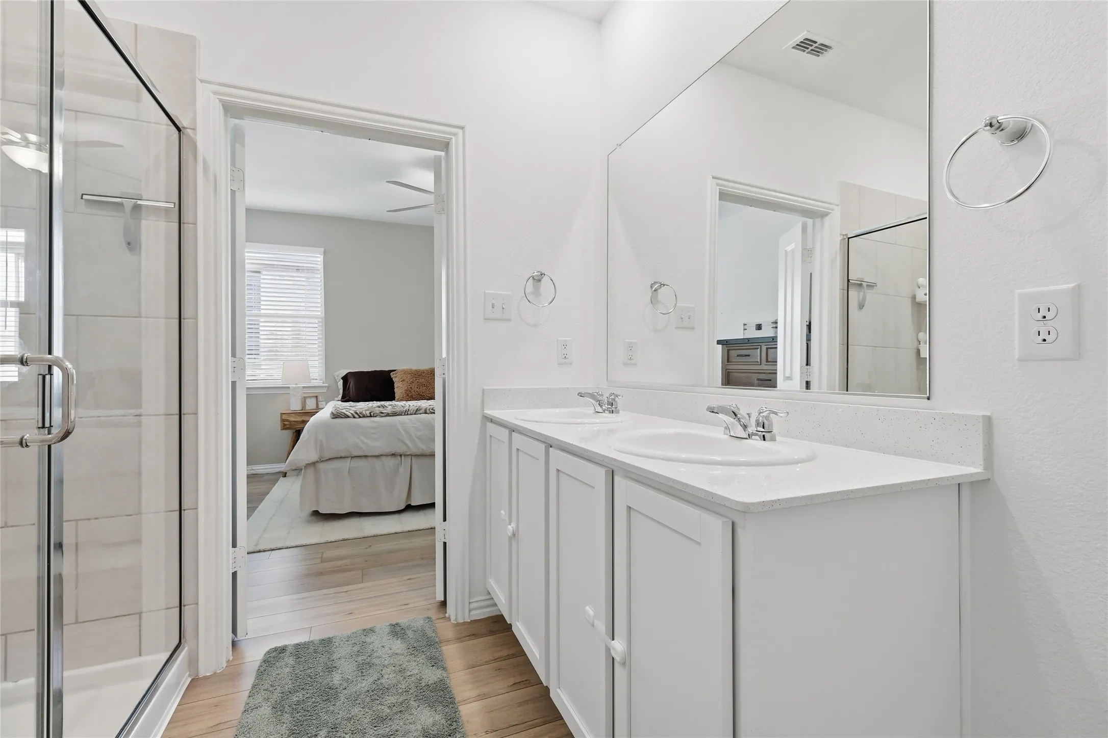 Bathroom featuring a dual vanity with white cabinetry and a light-colored countertop