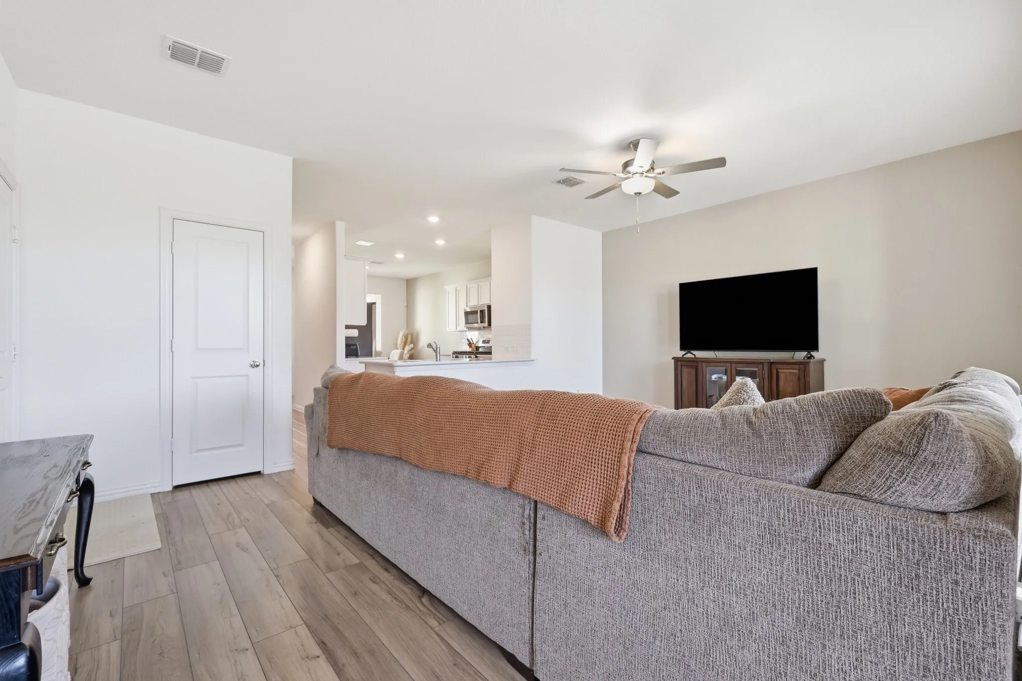 Open-concept living area featuring wood-finish flooring, a ceiling fan, and recessed lighting