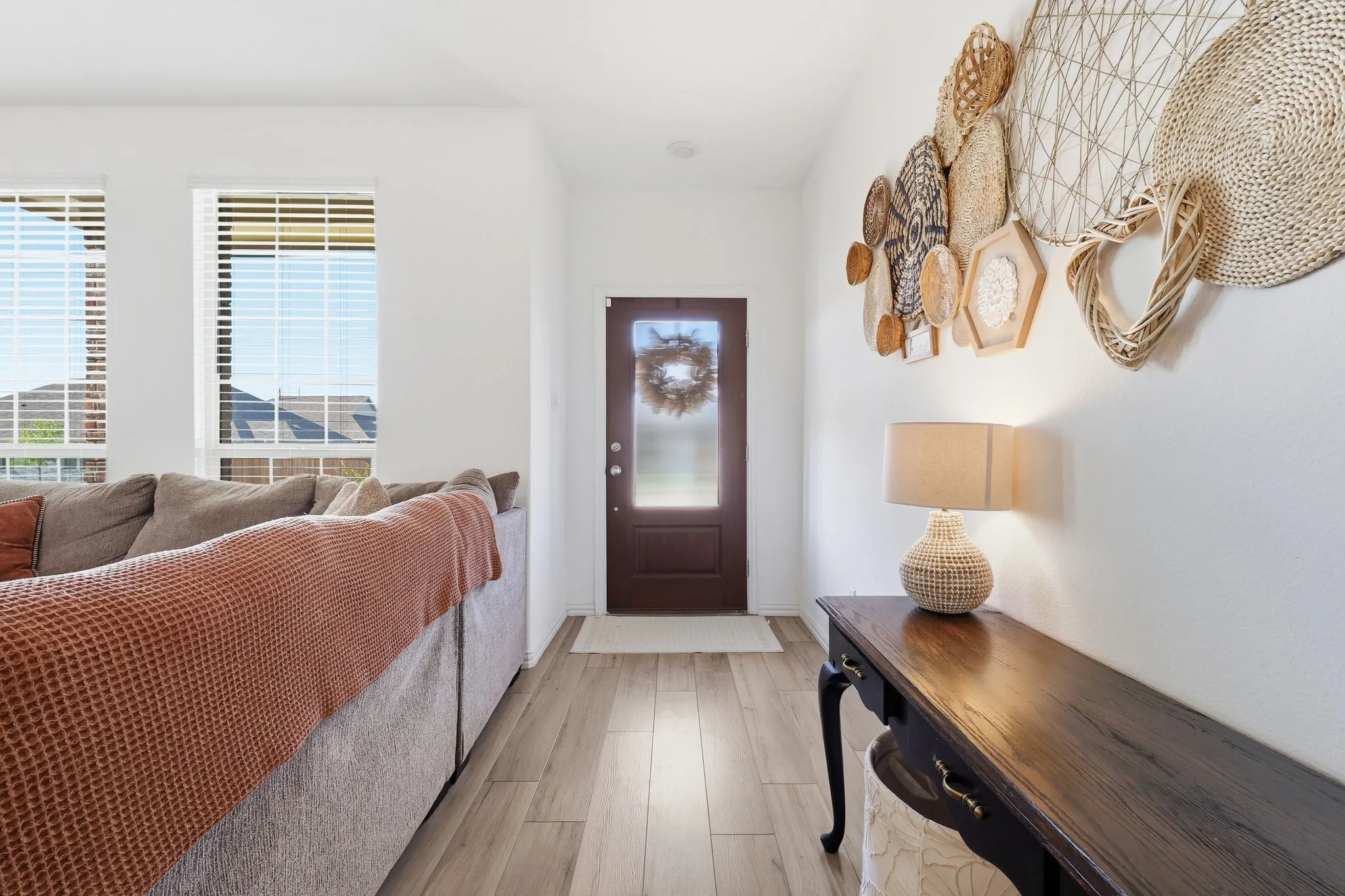 Entryway featuring wood-finish flooring, a dark wood-finish door with frosted glass, and white walls