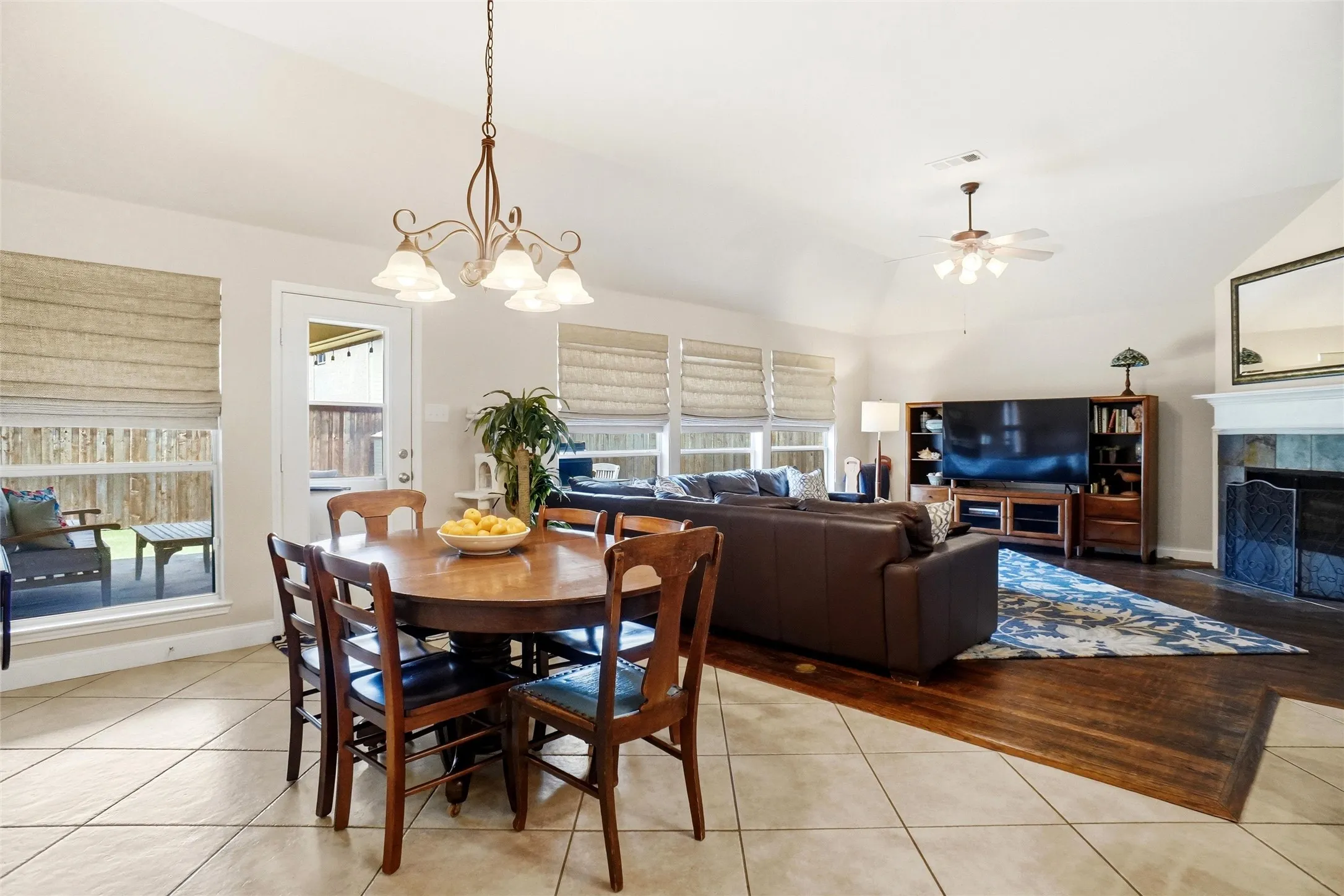 Open-concept living space featuring a vaulted ceiling and a fireplace with a tile surround