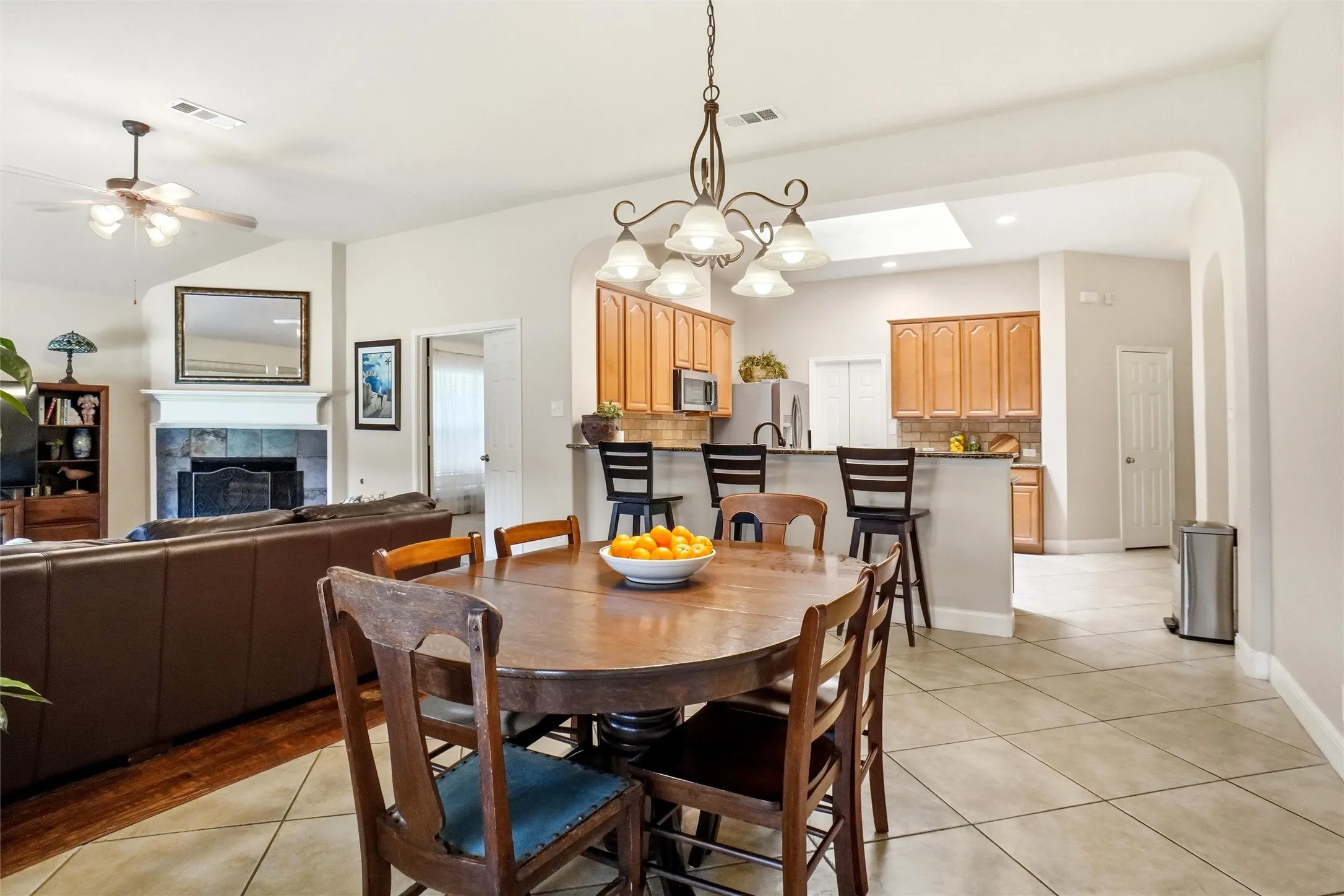 Dining area featuring a wood-finish table with seating for four, tile flooring, and an ornate chandelier
