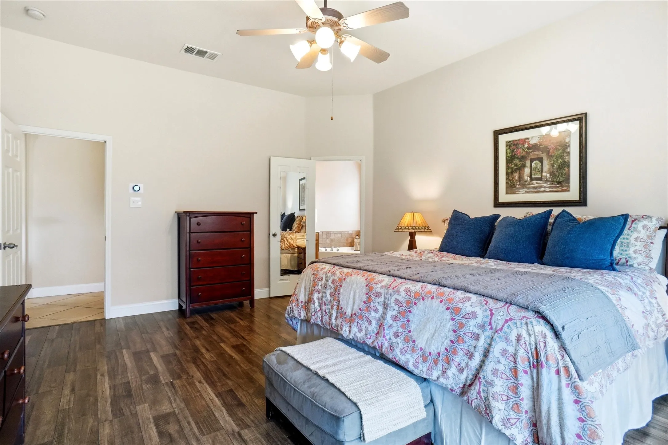 Spacious room with wood-finish flooring, vaulted ceiling, and ceiling fan