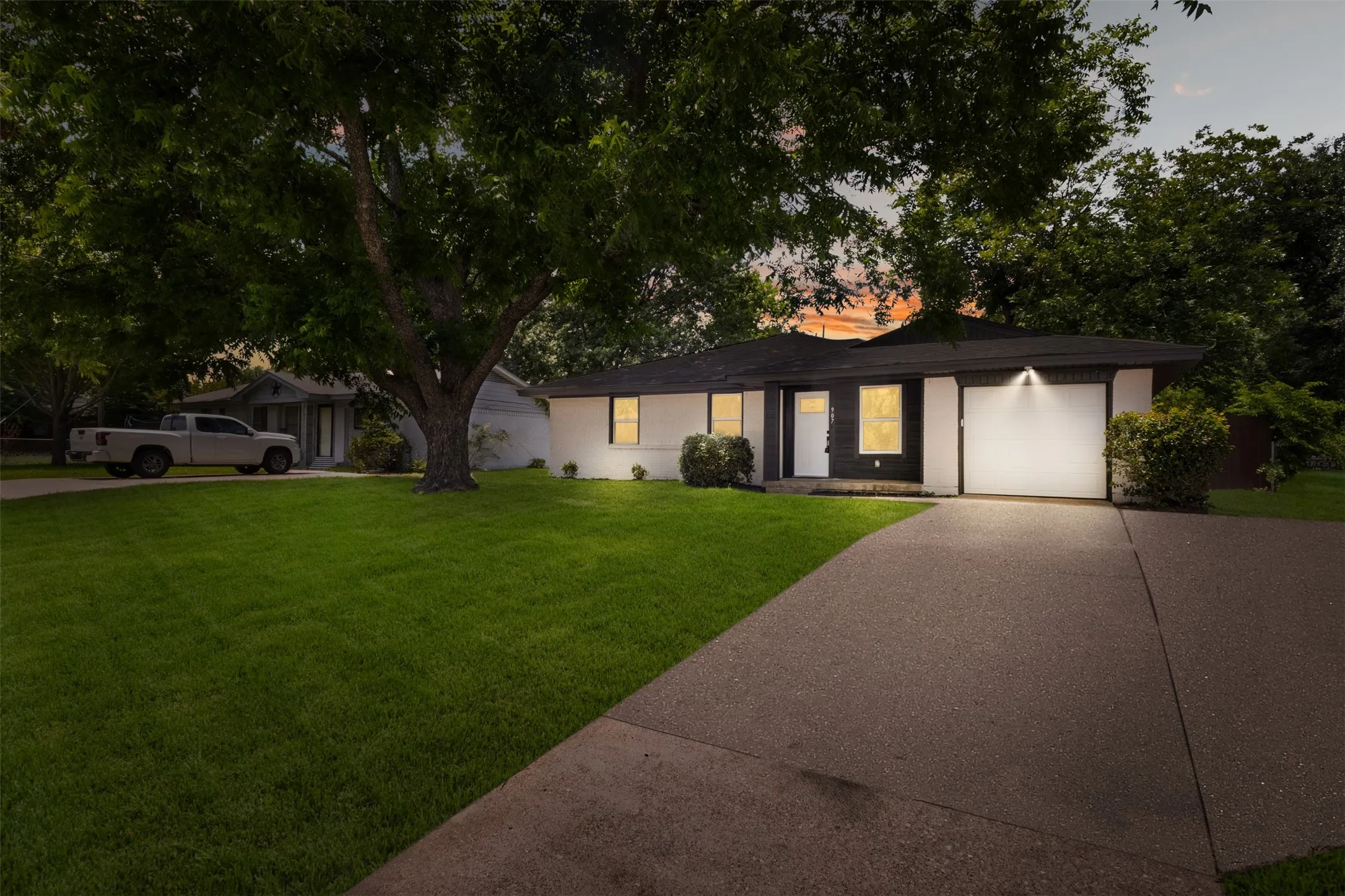 Contemporary single-story residence with a dark roof and white exterior siding