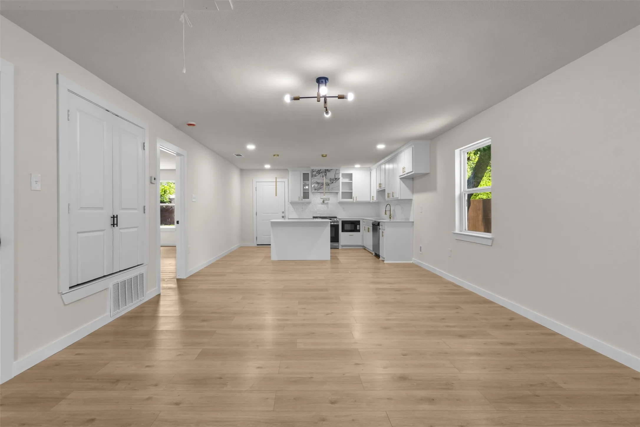Open concept living space featuring wood-finish flooring, recessed lighting, and a modern ceiling fixture