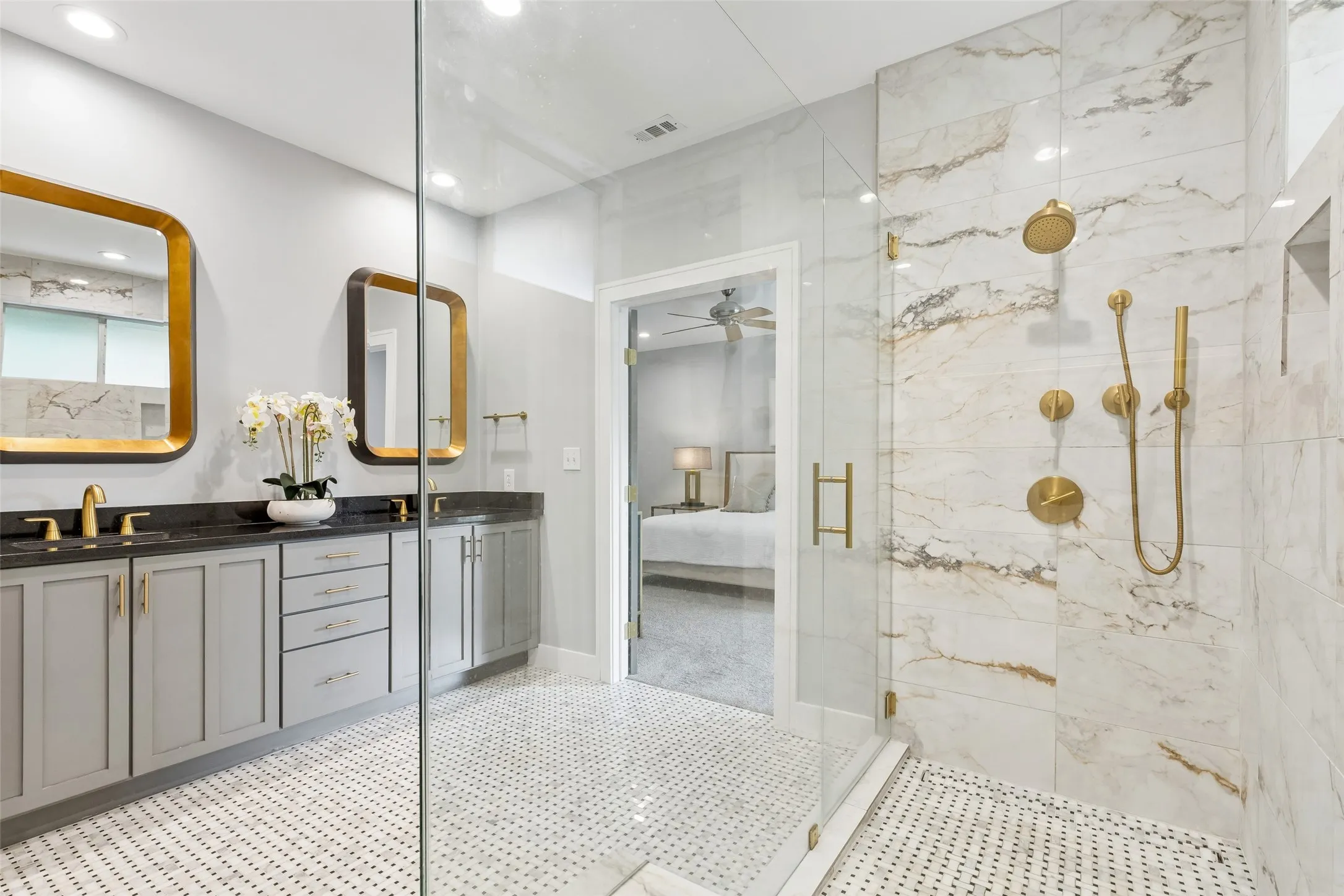 Spacious bathroom featuring a frameless glass shower enclosure with floor-to-ceiling marble-look tile