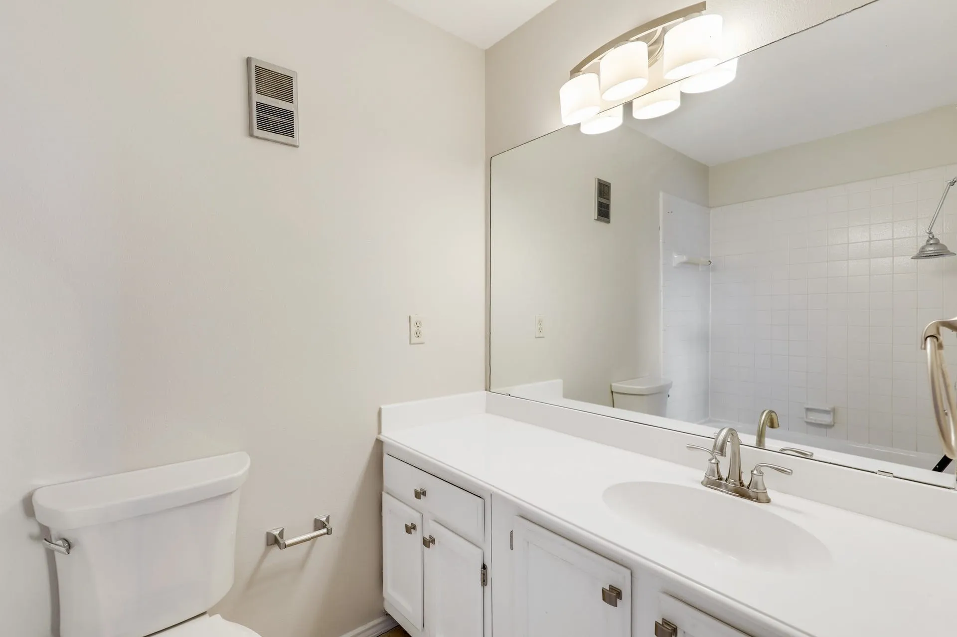 Bathroom vanity with an integrated sink, white cabinetry, and brushed nickel hardware