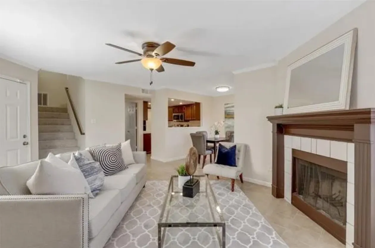 Living area featuring a traditional fireplace with a white tile surround and a wood mantel