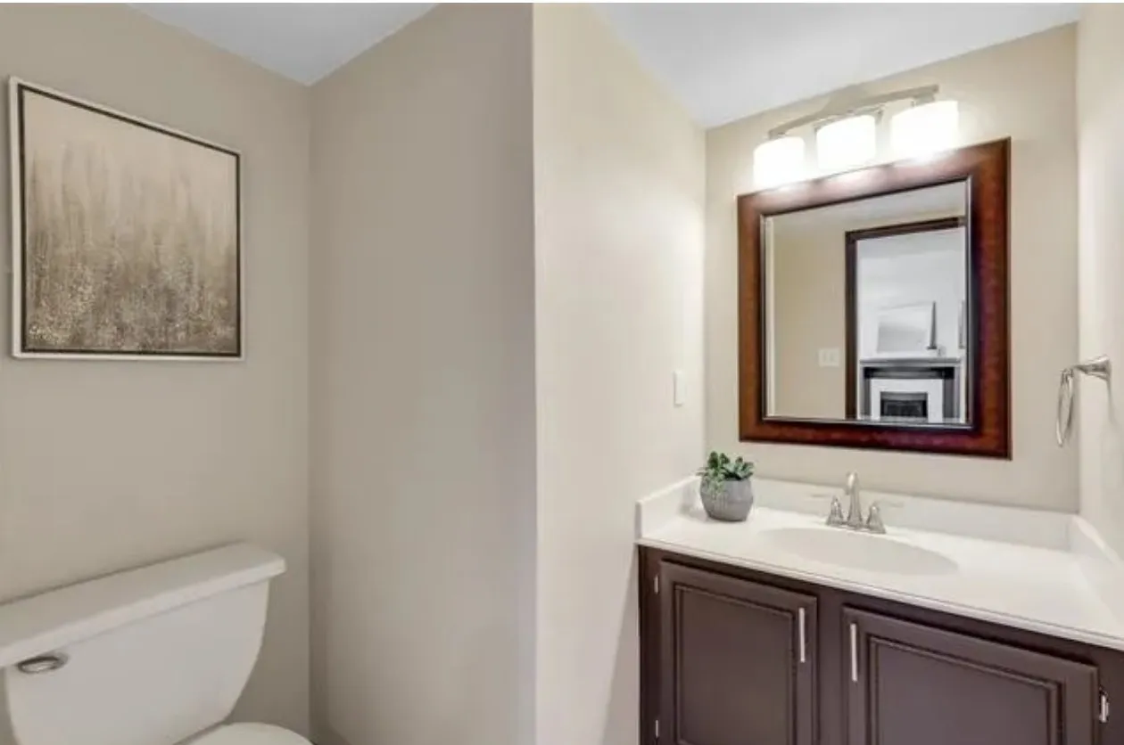 Vanity featuring a white countertop, undermount sink, and dark wood-finish cabinetry