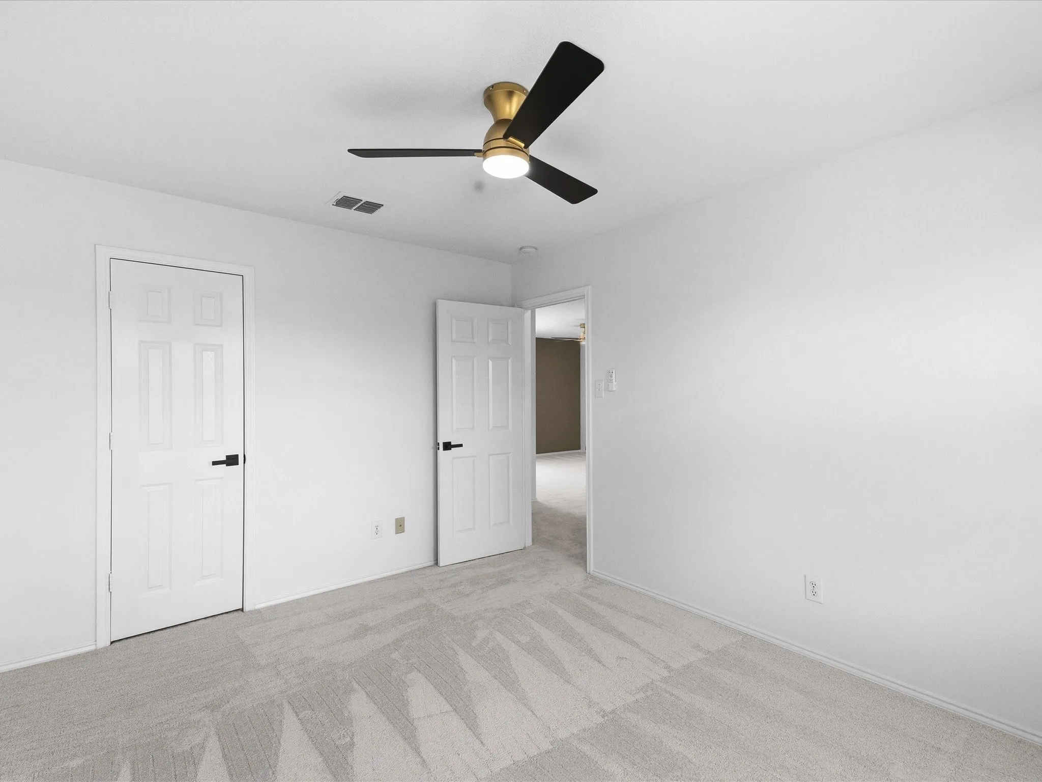 Room featuring light grey patterned carpeting and crisp white walls