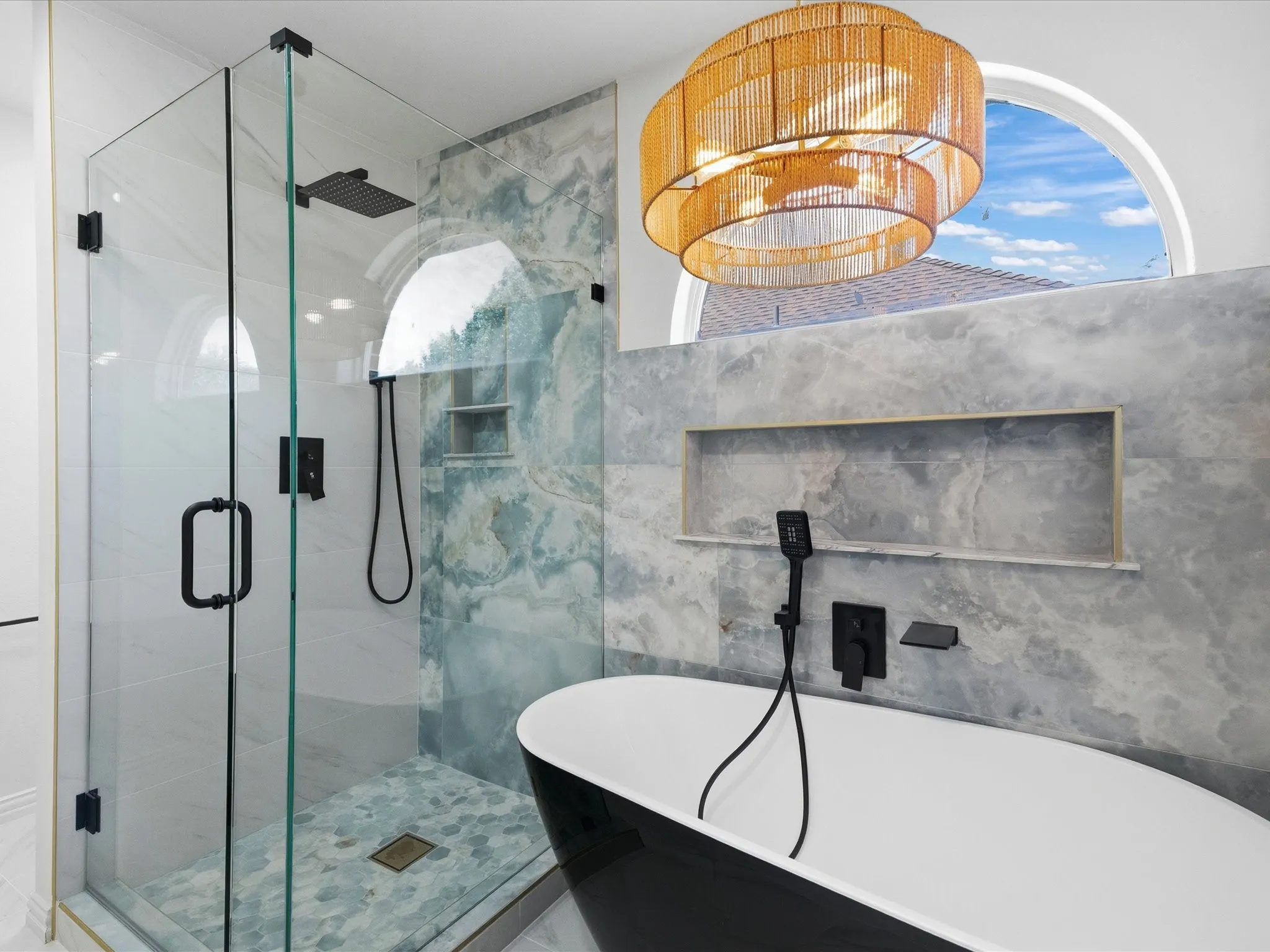 Contemporary bathroom featuring a black freestanding bathtub with matte black fixtures, a glass-enclosed shower with a rain showerhead, and a mosaic tile shower floor