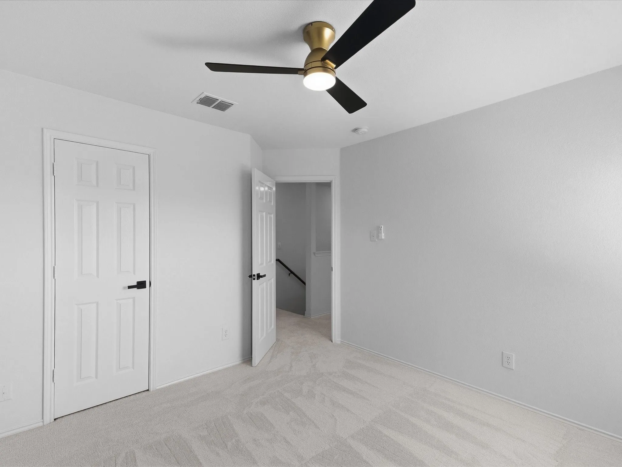 Bright interior space featuring white walls and light-toned carpeting