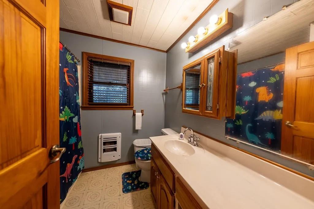 Bathroom featuring a single vanity with an integrated sink, wood cabinetry, and a mirrored medicine cabinet