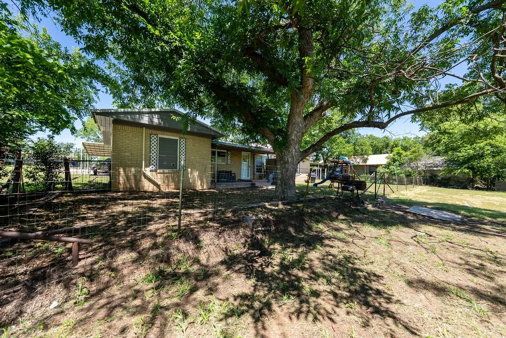 Expansive property featuring mature trees and a brick exterior
