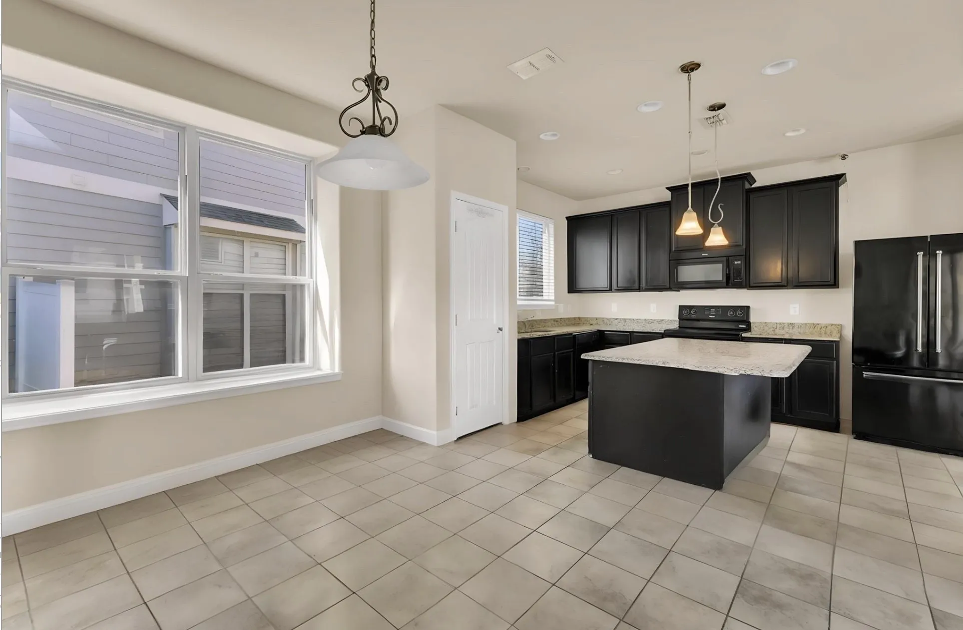 Kitchen featuring dark cabinetry, lighter countertops, and a central island