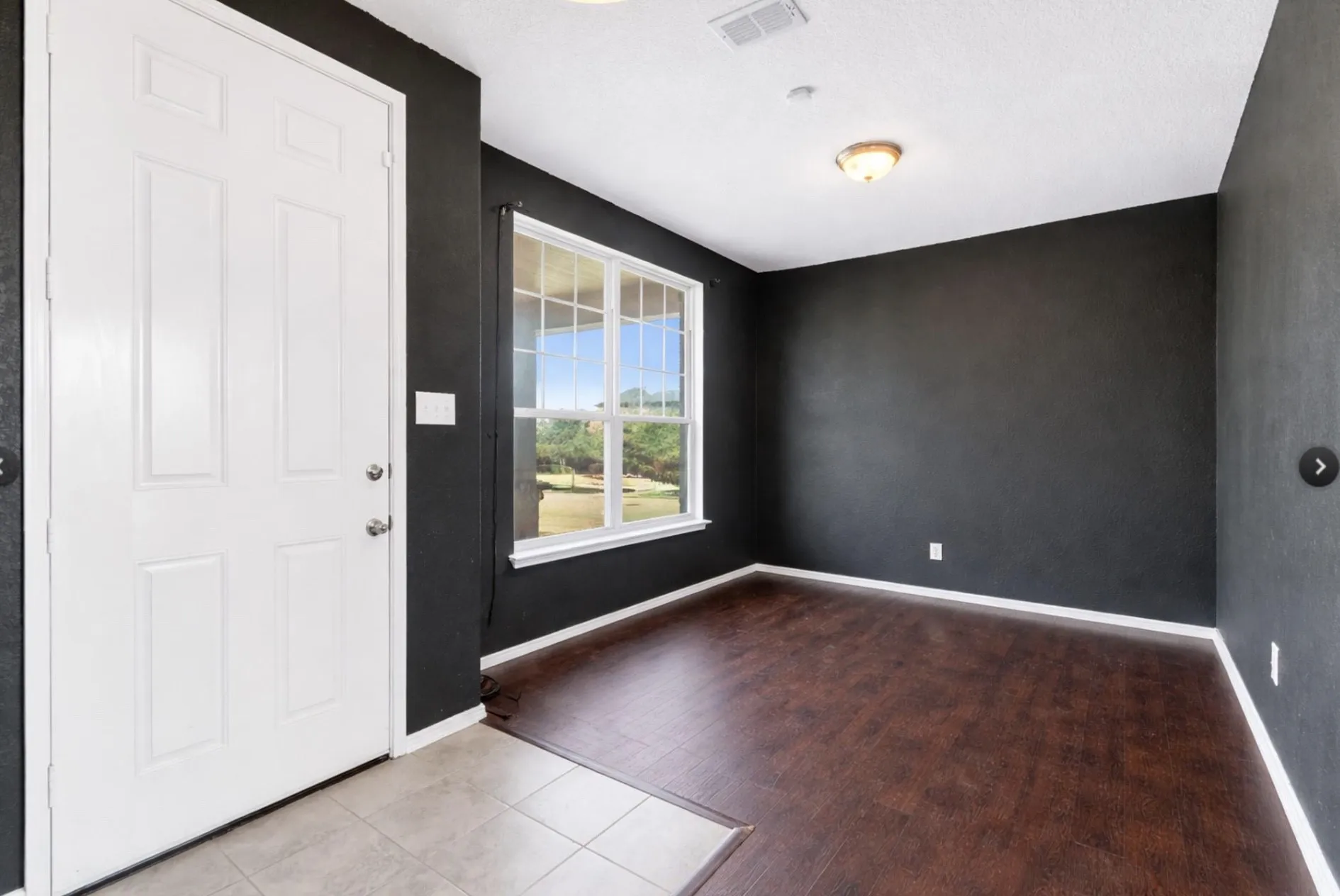 Entryway featuring a white paneled door, wood-finish flooring, and a large window