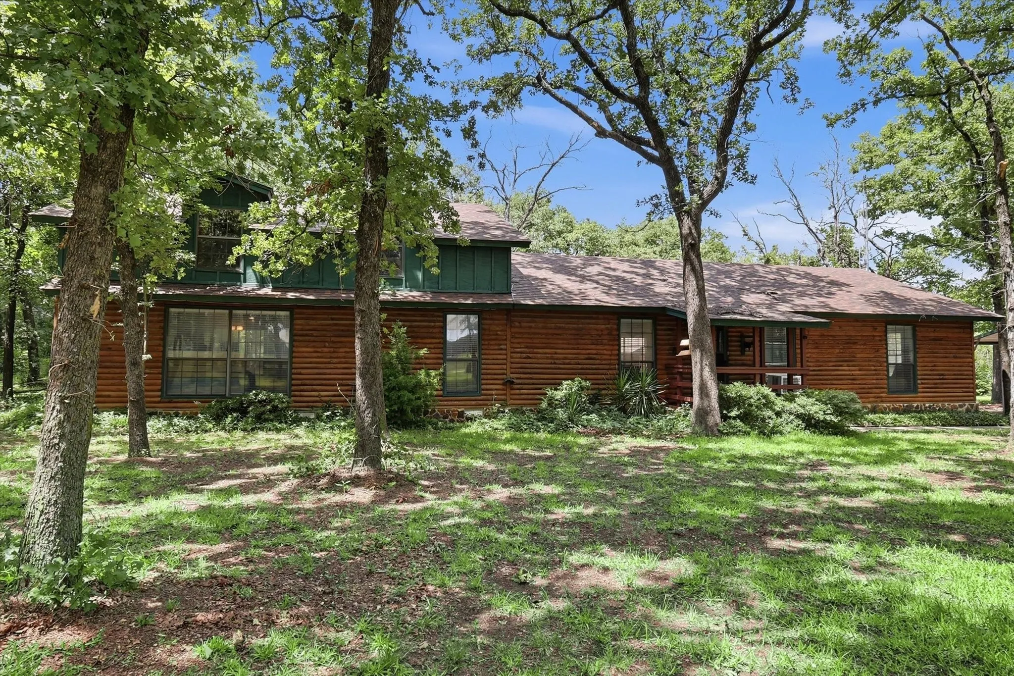Rustic style home with natural wood siding and a green gabled accent