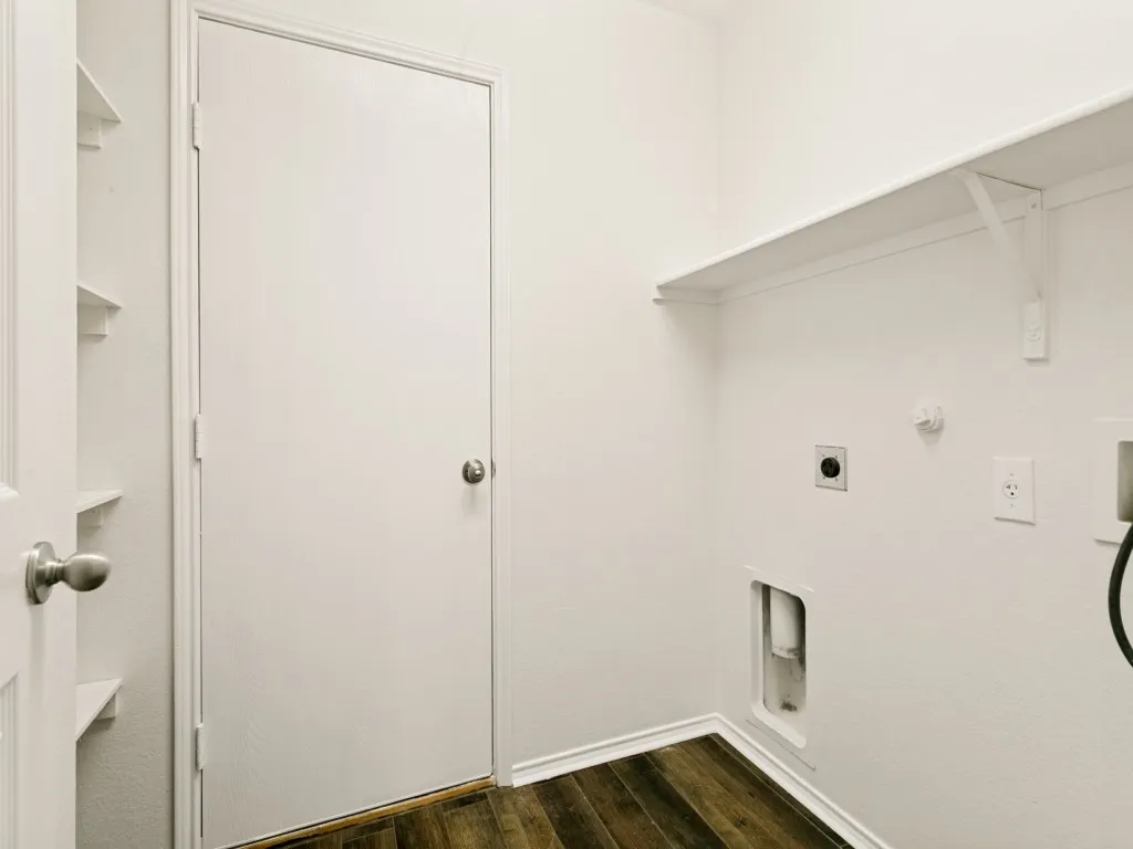 Utility room featuring wood-finish flooring, white walls, and built-in shelving