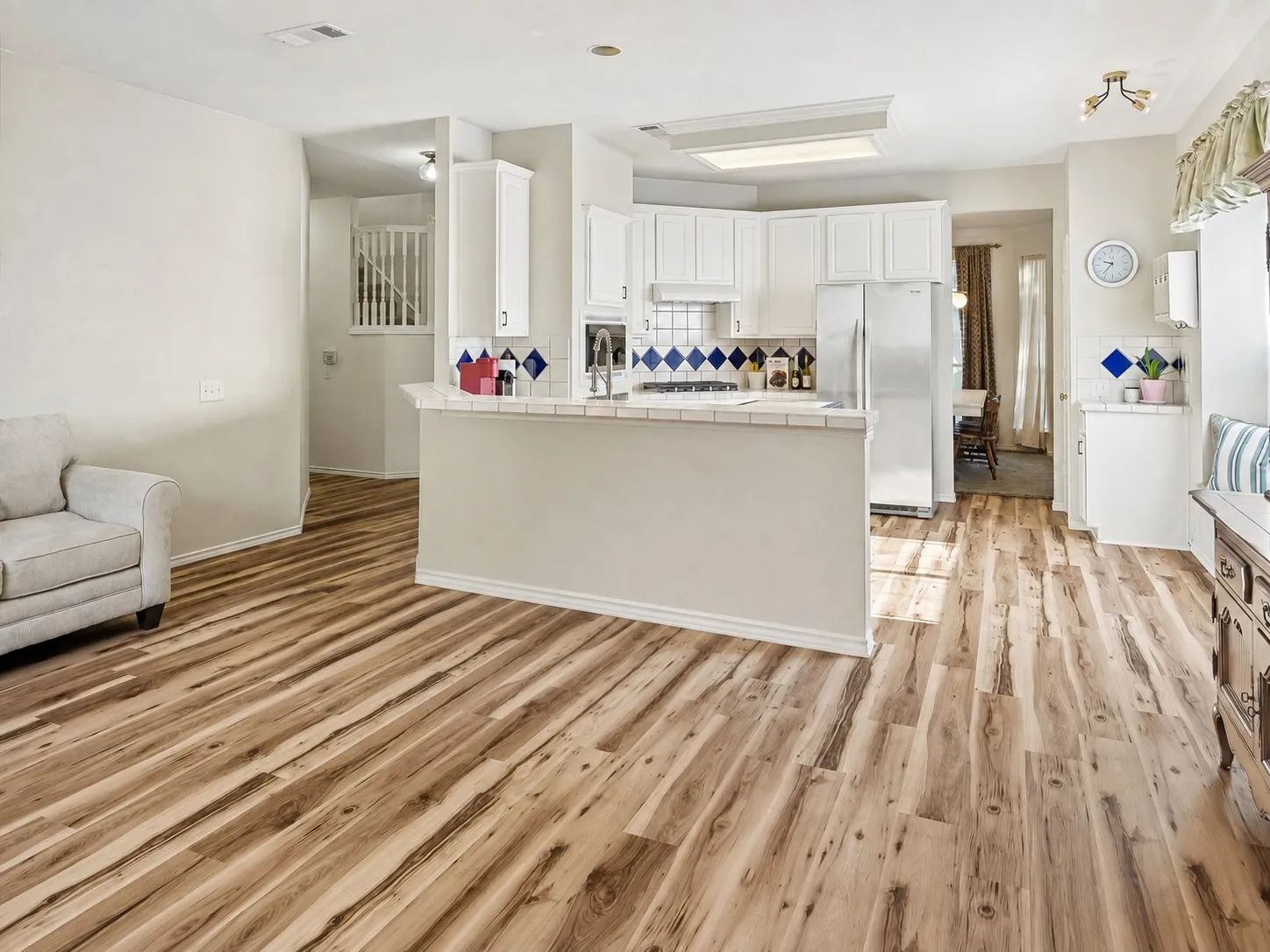 Open-concept kitchen with white cabinetry and stainless steel appliances