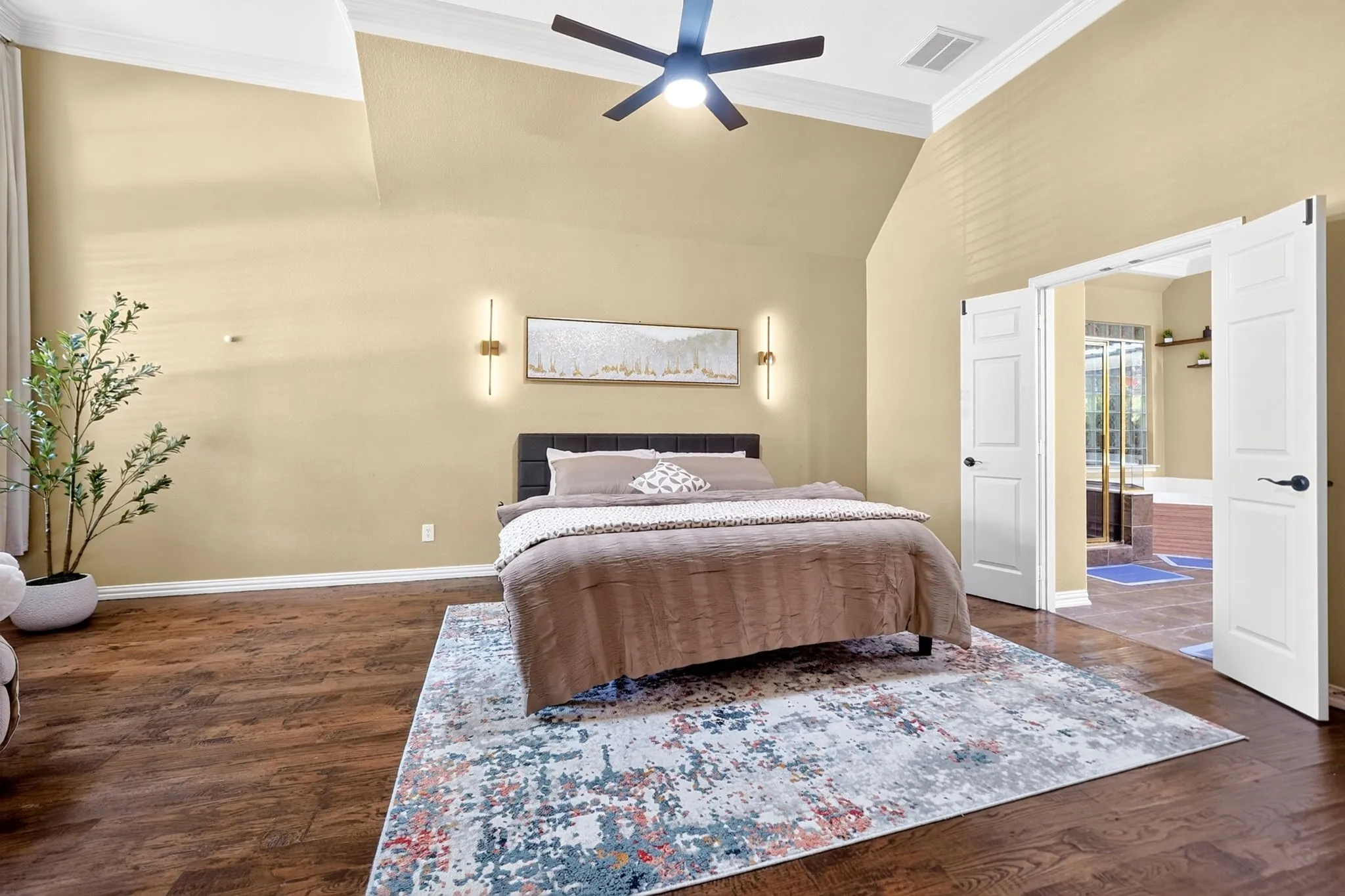 Spacious room featuring wood-finish flooring, vaulted ceilings, and a contemporary ceiling fan