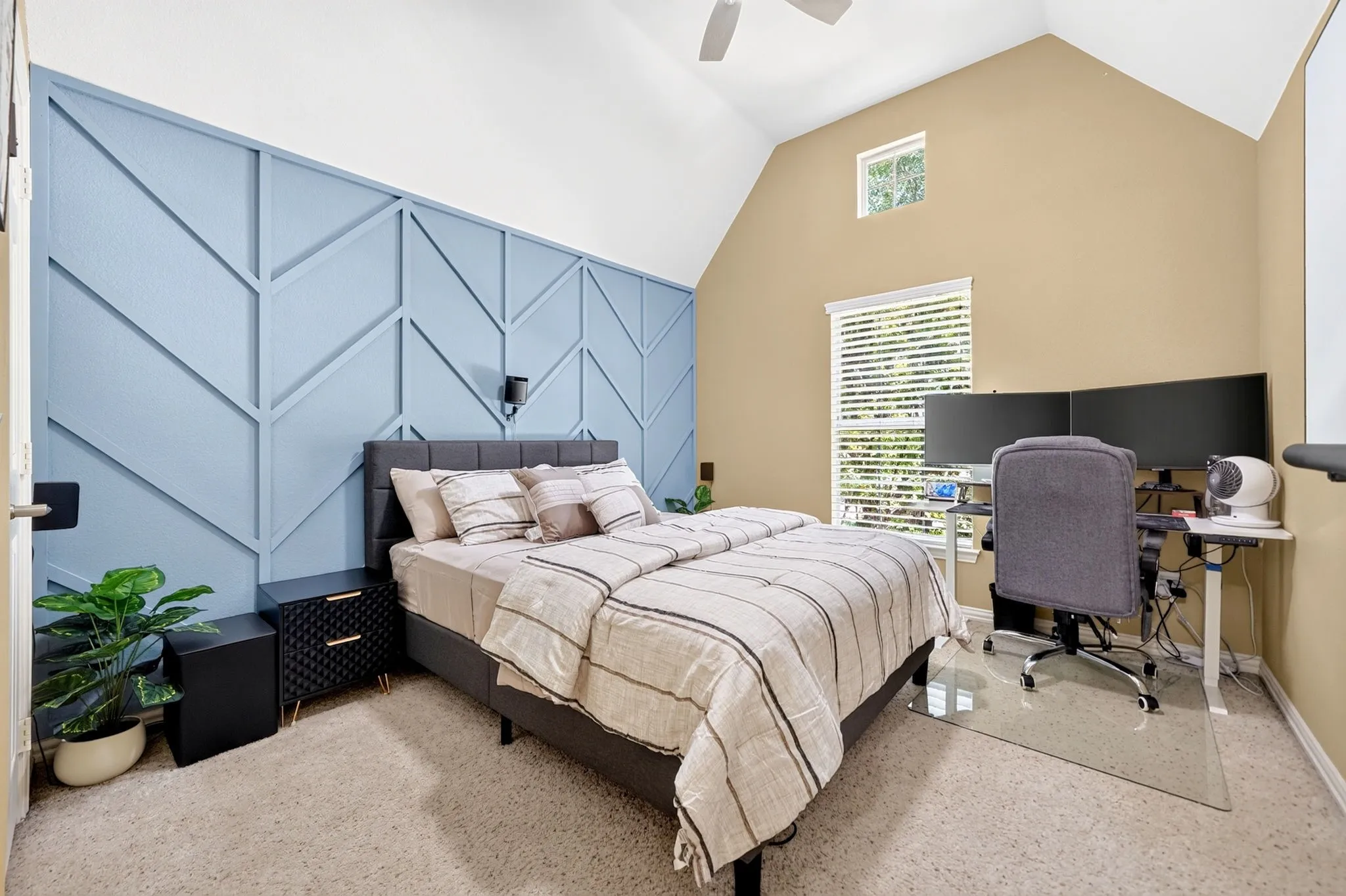 Room featuring a vaulted ceiling and a decorative accent wall with geometric paneling
