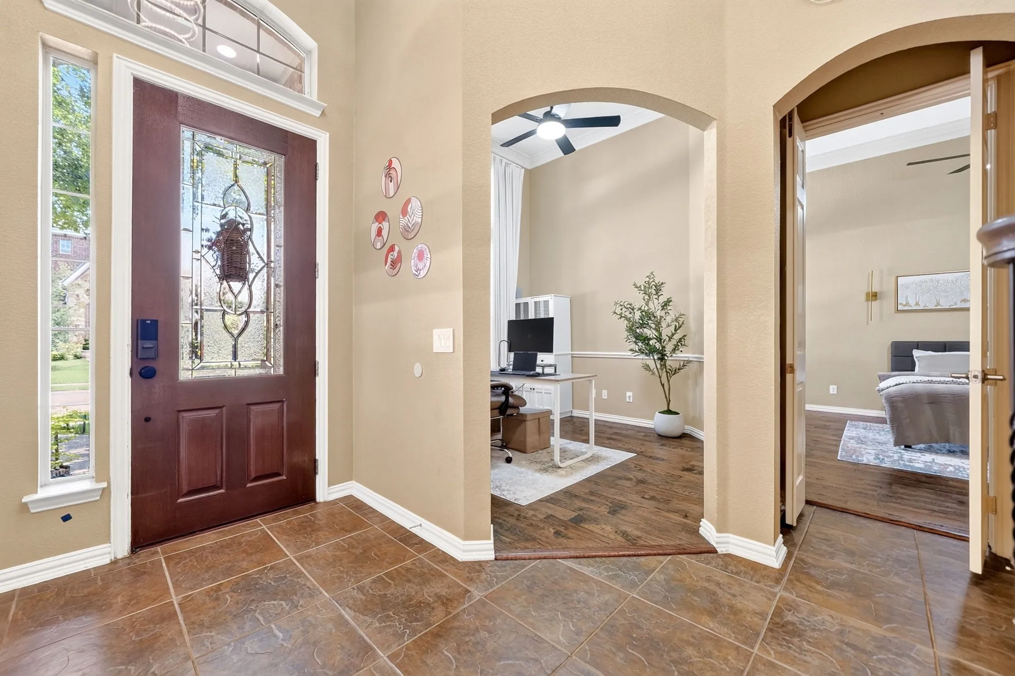 Entry foyer with tile flooring leading to an arched doorway