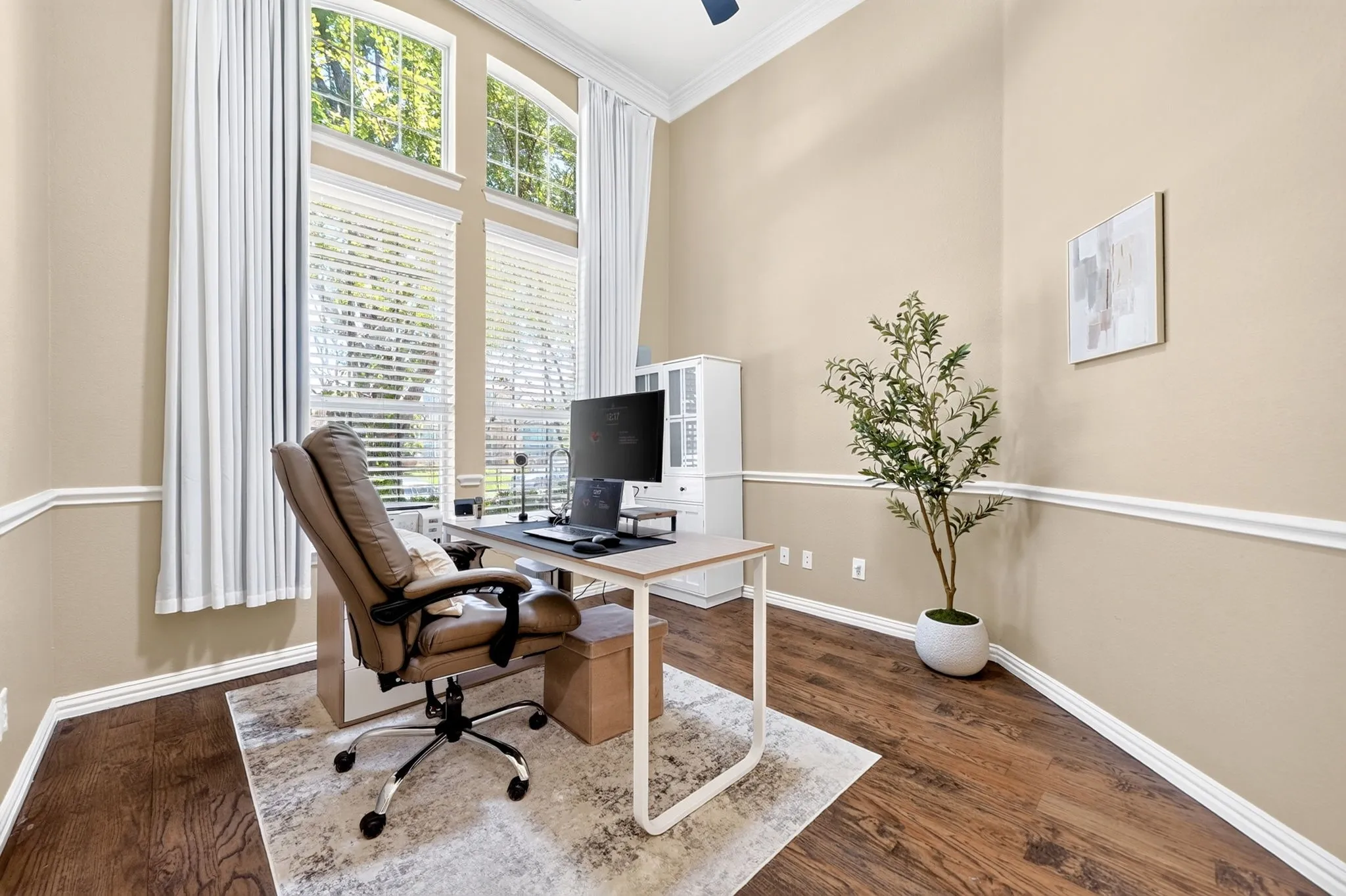 Room featuring high ceilings, wood-finish flooring, and crown molding