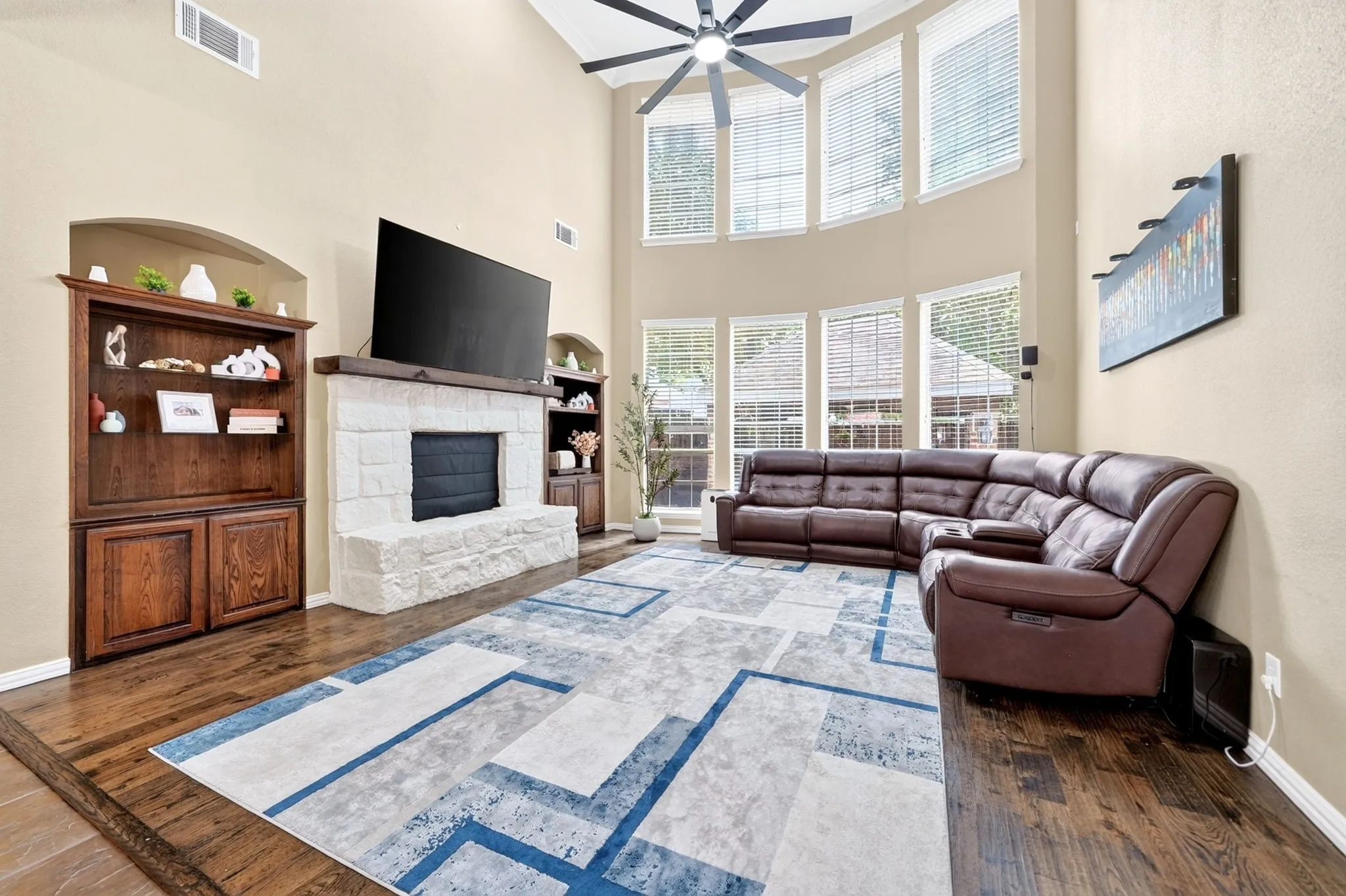 Spacious living area featuring double-height ceilings and wood-finish flooring