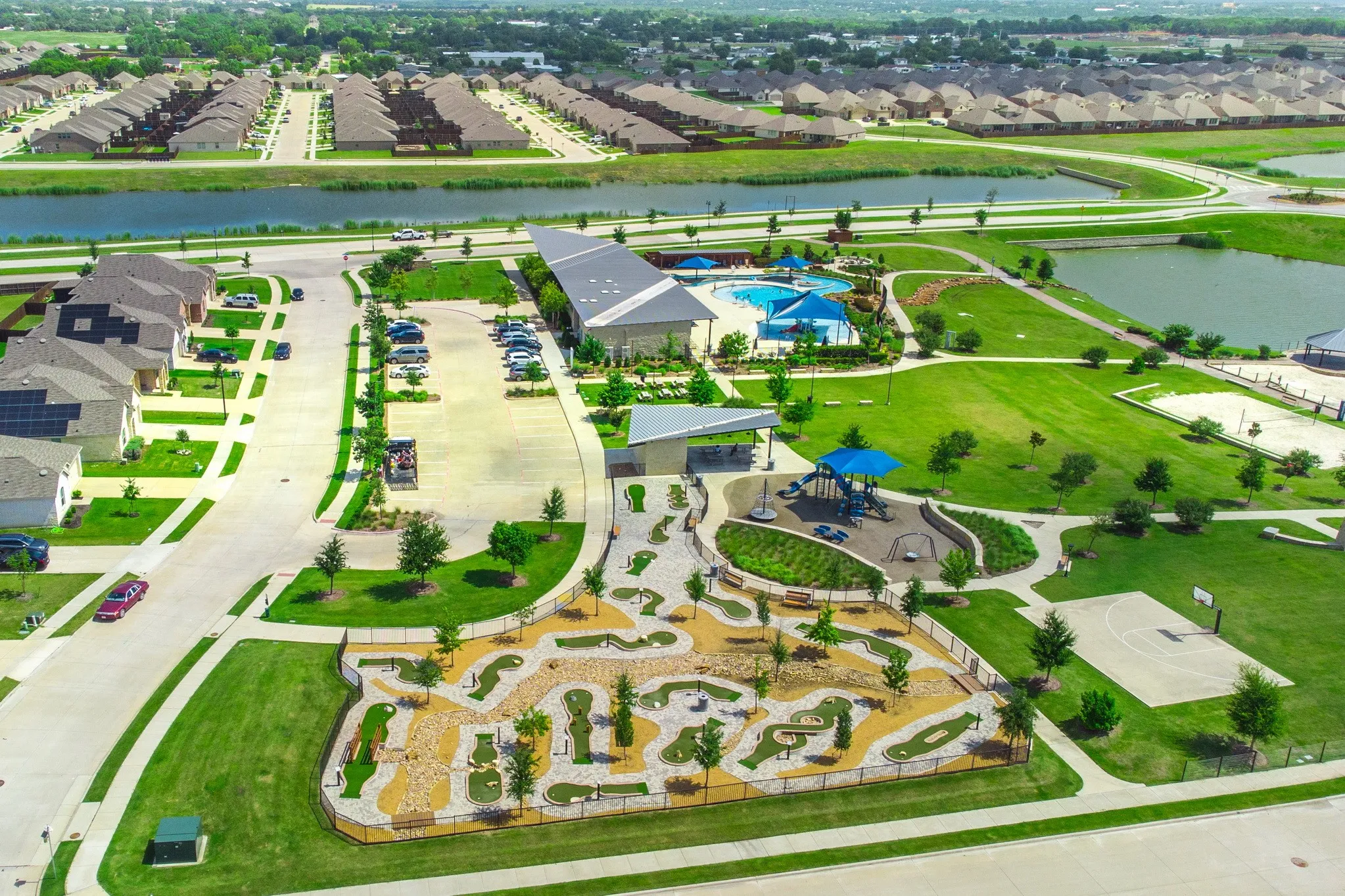 Community amenities featuring a miniature golf course, swimming pool with deck, playground with shade structure, and a basketball court