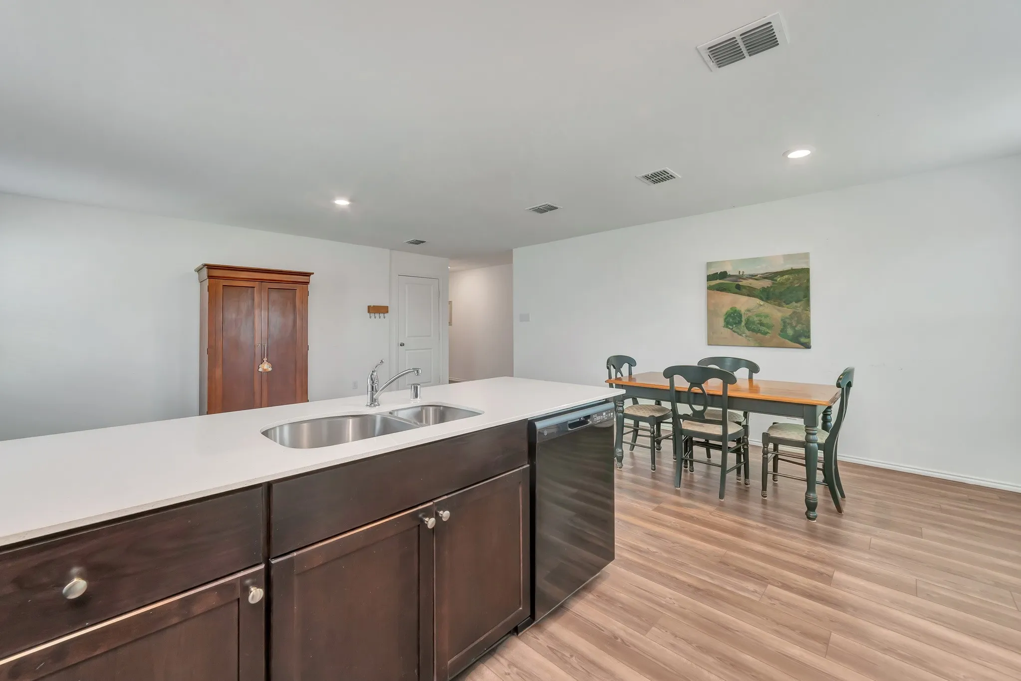 Kitchen island featuring a double basin stainless steel sink with a gooseneck faucet