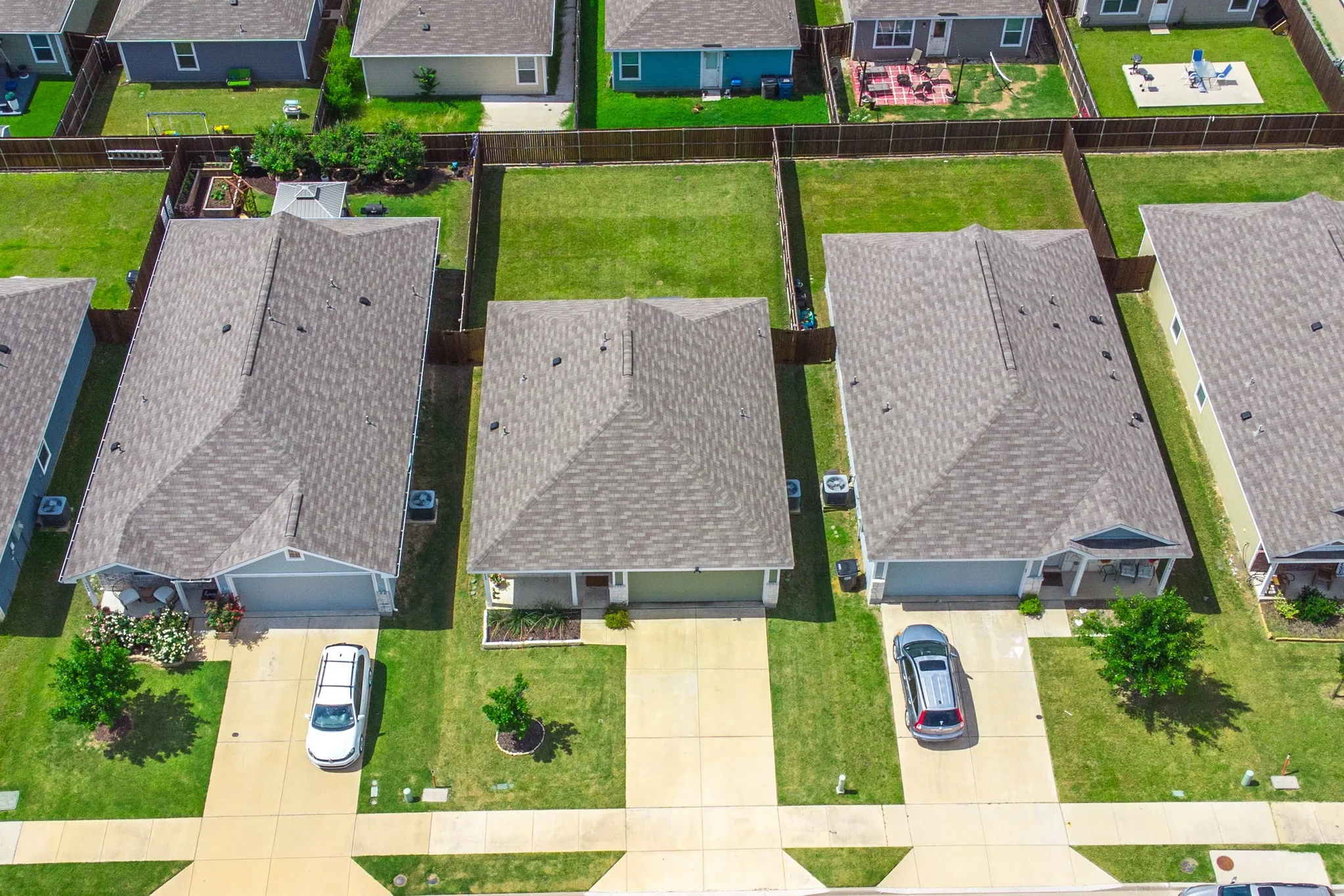 Aerial view showcasing a residential property with a shingled roof and a light blue exterior
