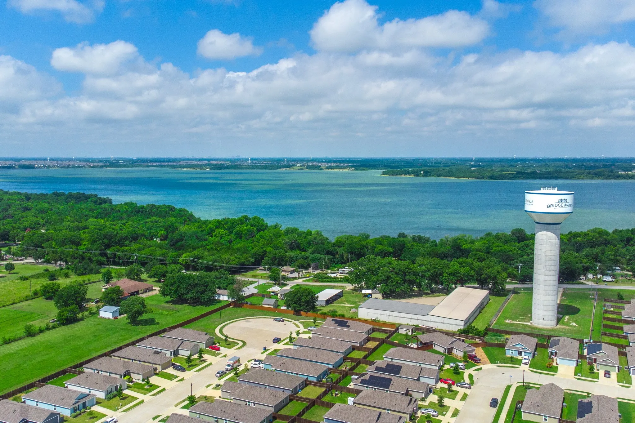 Aerial perspective showcasing a water body, verdant shoreline, and residential developments
