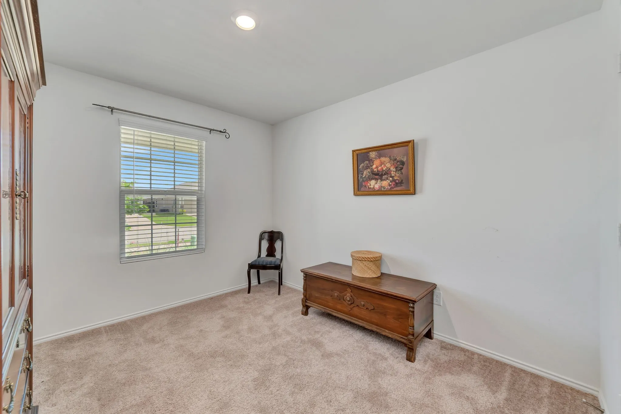 Neutral wall color, recessed ceiling light, and window with blinds
